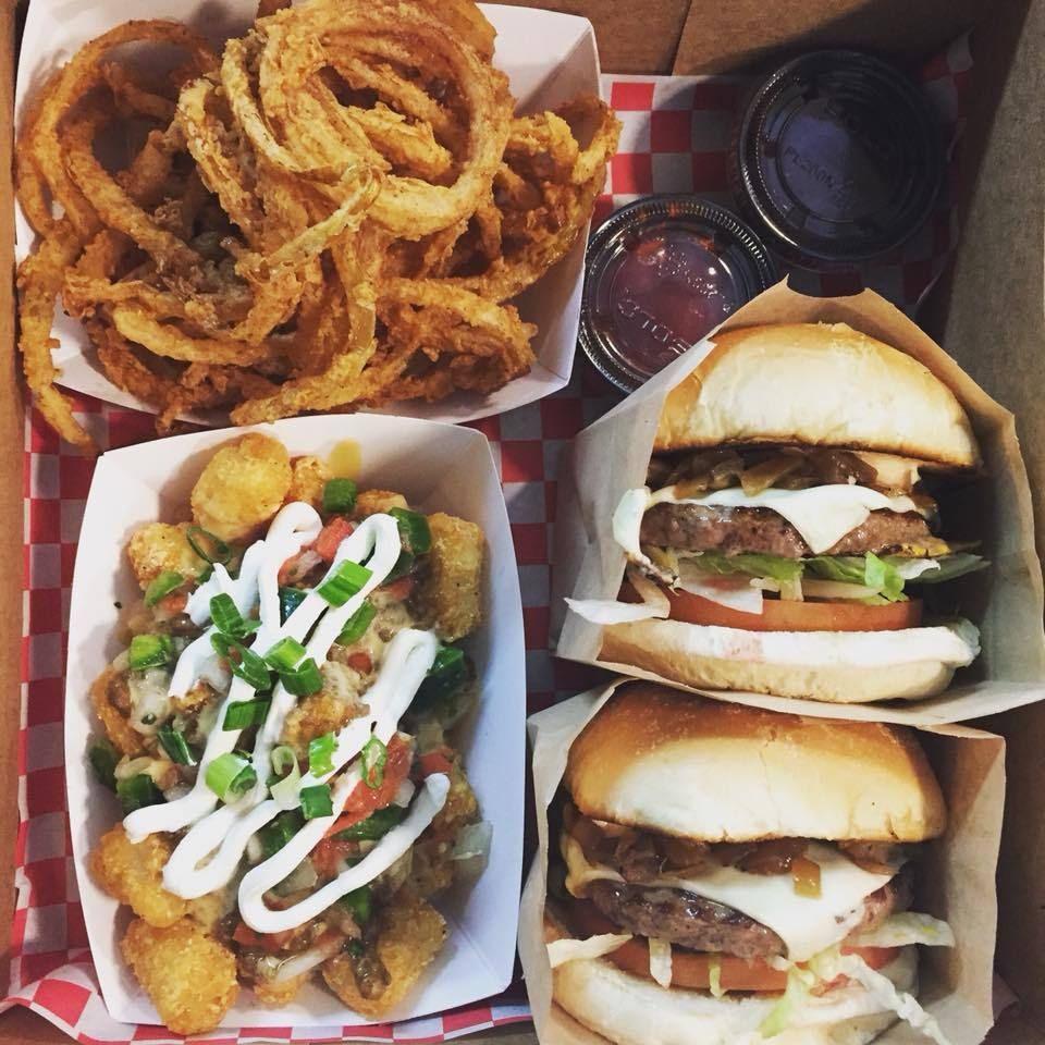 A box of food including burgers and onion rings