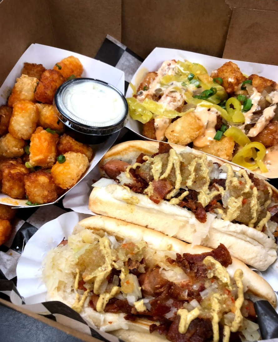 A box of food including hot dogs and potatoes