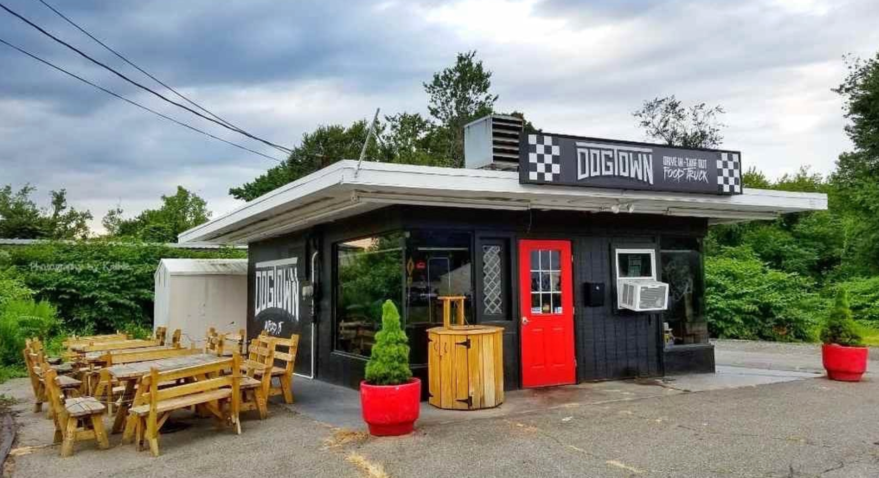 A restaurant with tables and chairs in front of it.
