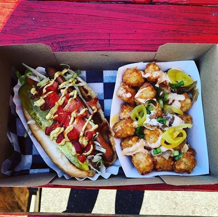 A hot dog and a plate of food are in a box