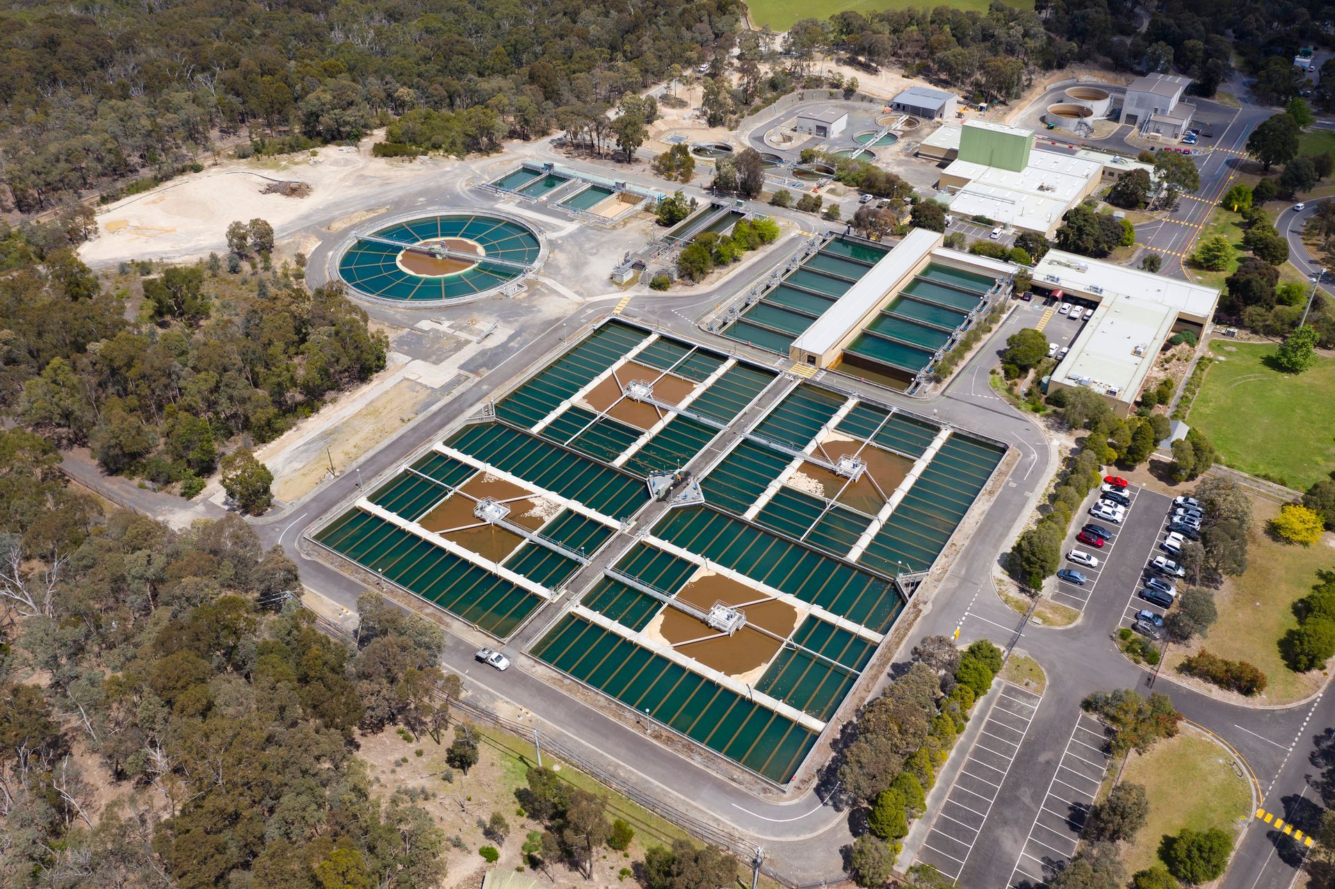 An aerial view of a large water treatment plant surrounded by trees.