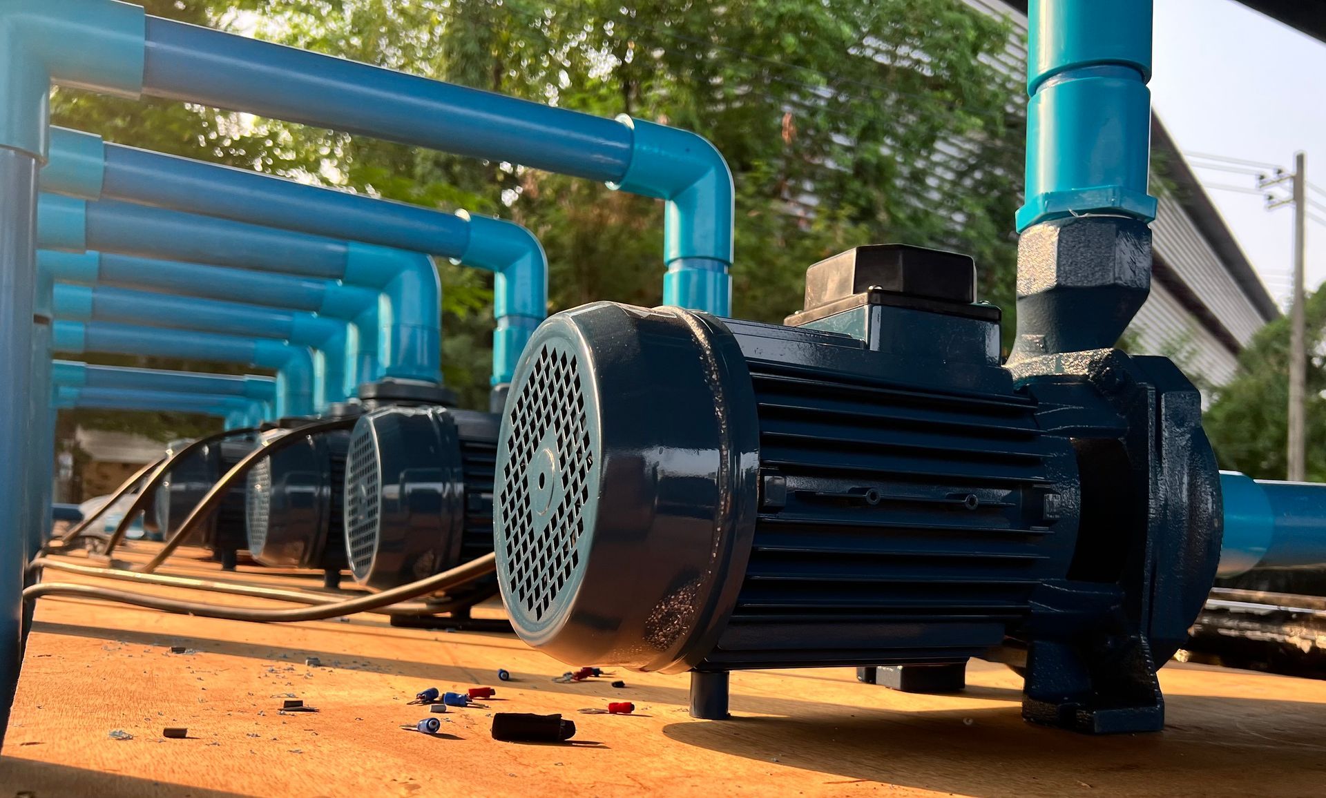 A group of water pumps are sitting next to each other on the ground.