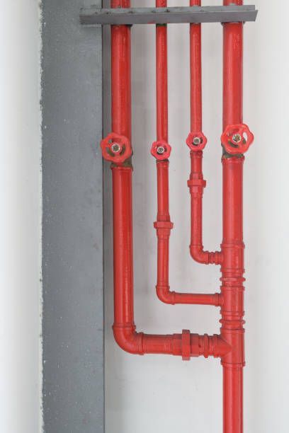 A bunch of red pipes on a white wall