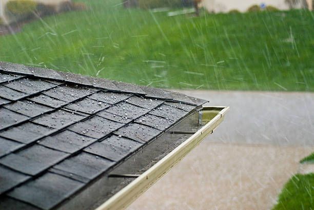 It is raining on the roof of a house.