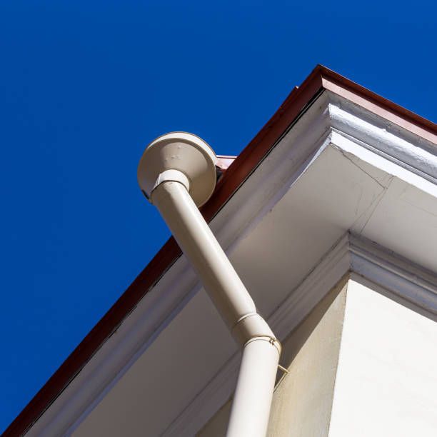 Looking up at the gutter of a house with a blue sky in the background