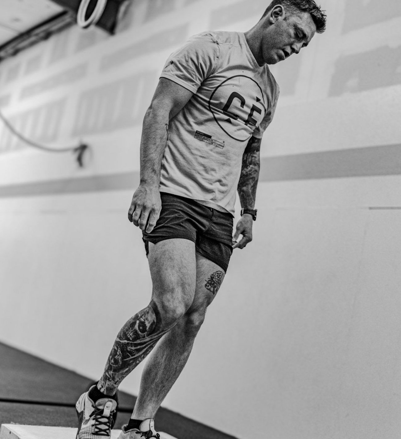 A man is lifting a barbell over his head in a gym.