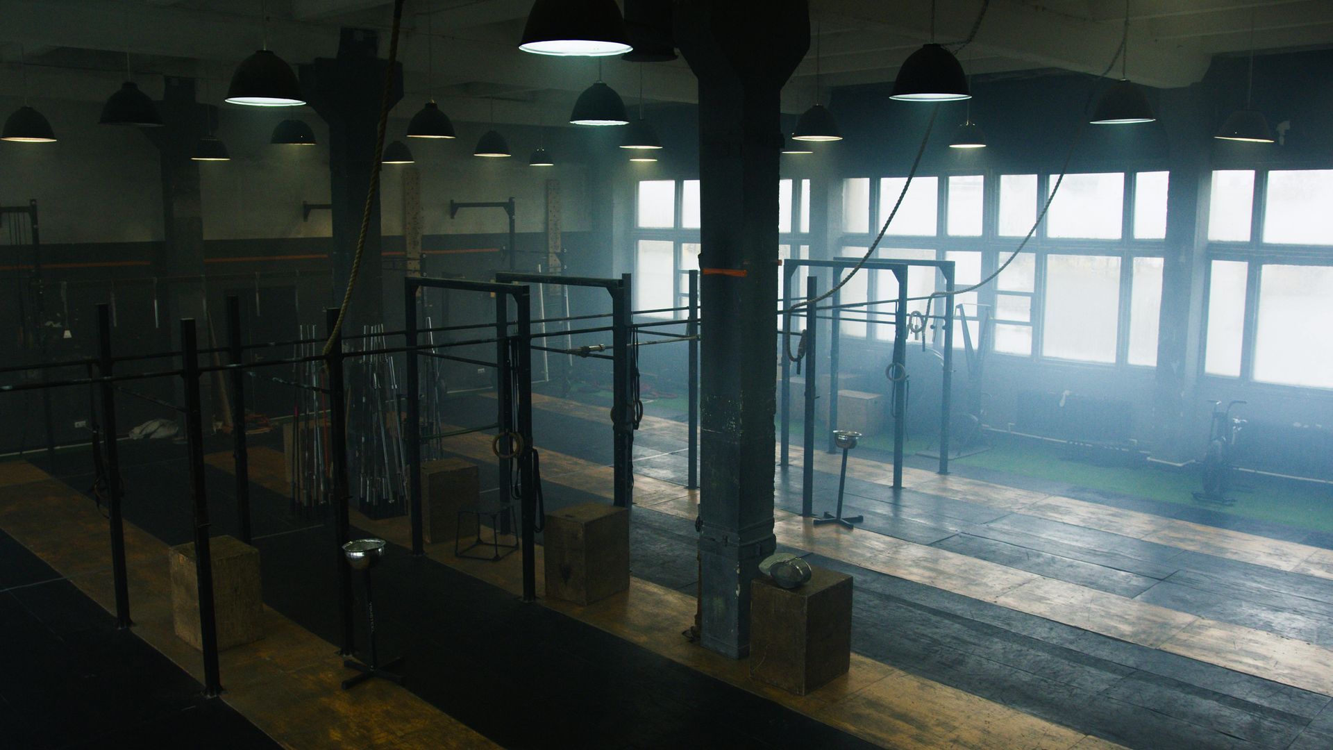 A gym with a lot of equipment and a lot of smoke coming out of the windows.