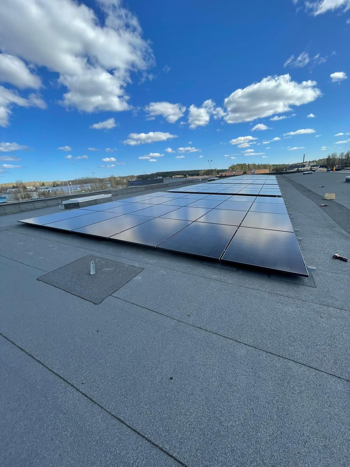 En rad solpaneler sitter på toppen av ett tak.