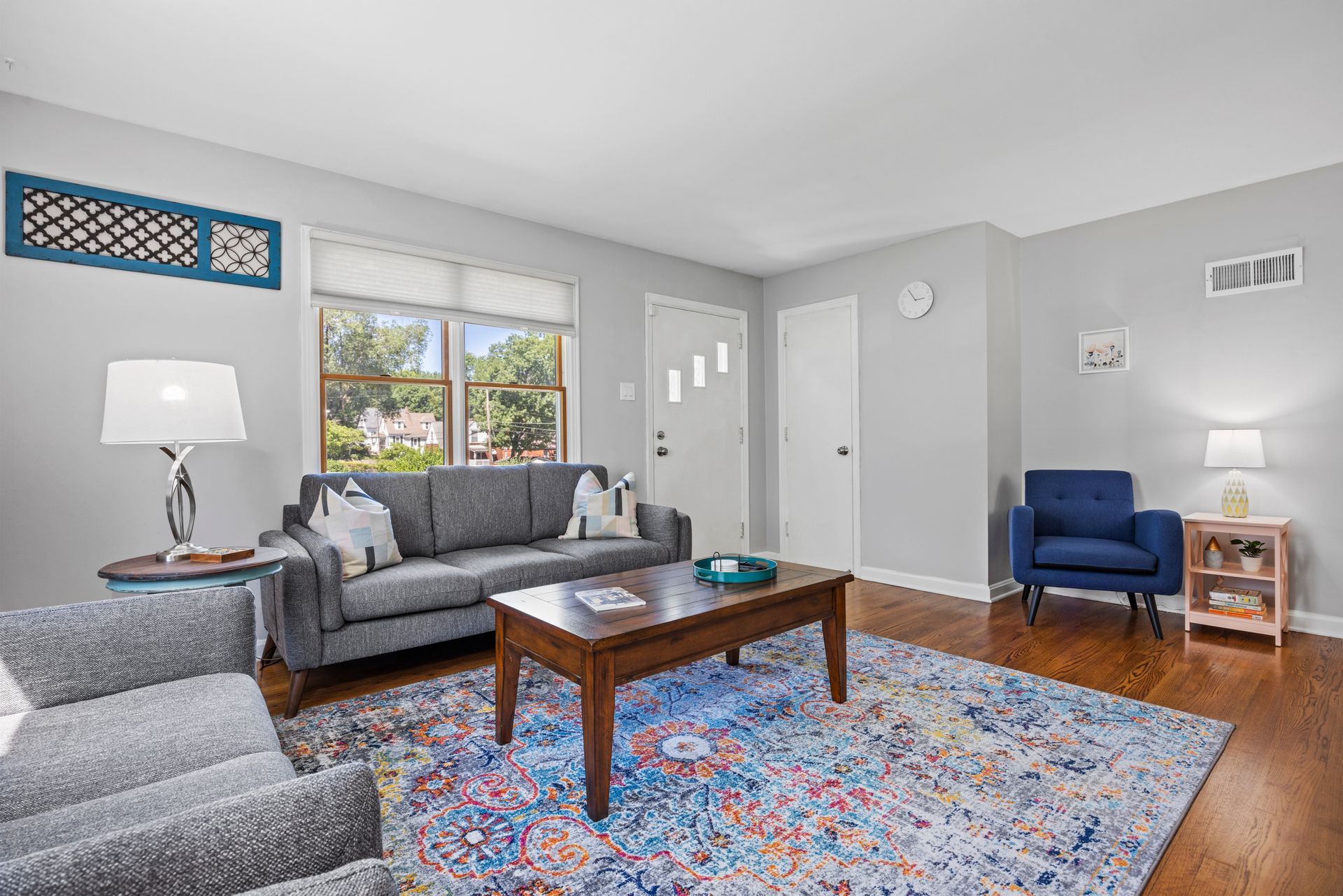 A living room with a couch , chairs , coffee table and rug.