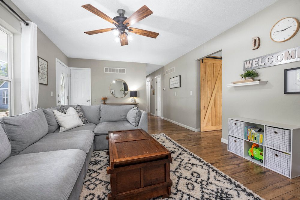 A living room with a couch , coffee table , and ceiling fan.