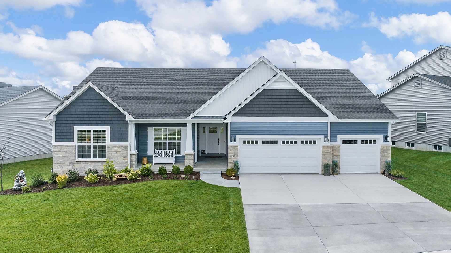 A house with a blue siding and a white garage door is for sale.