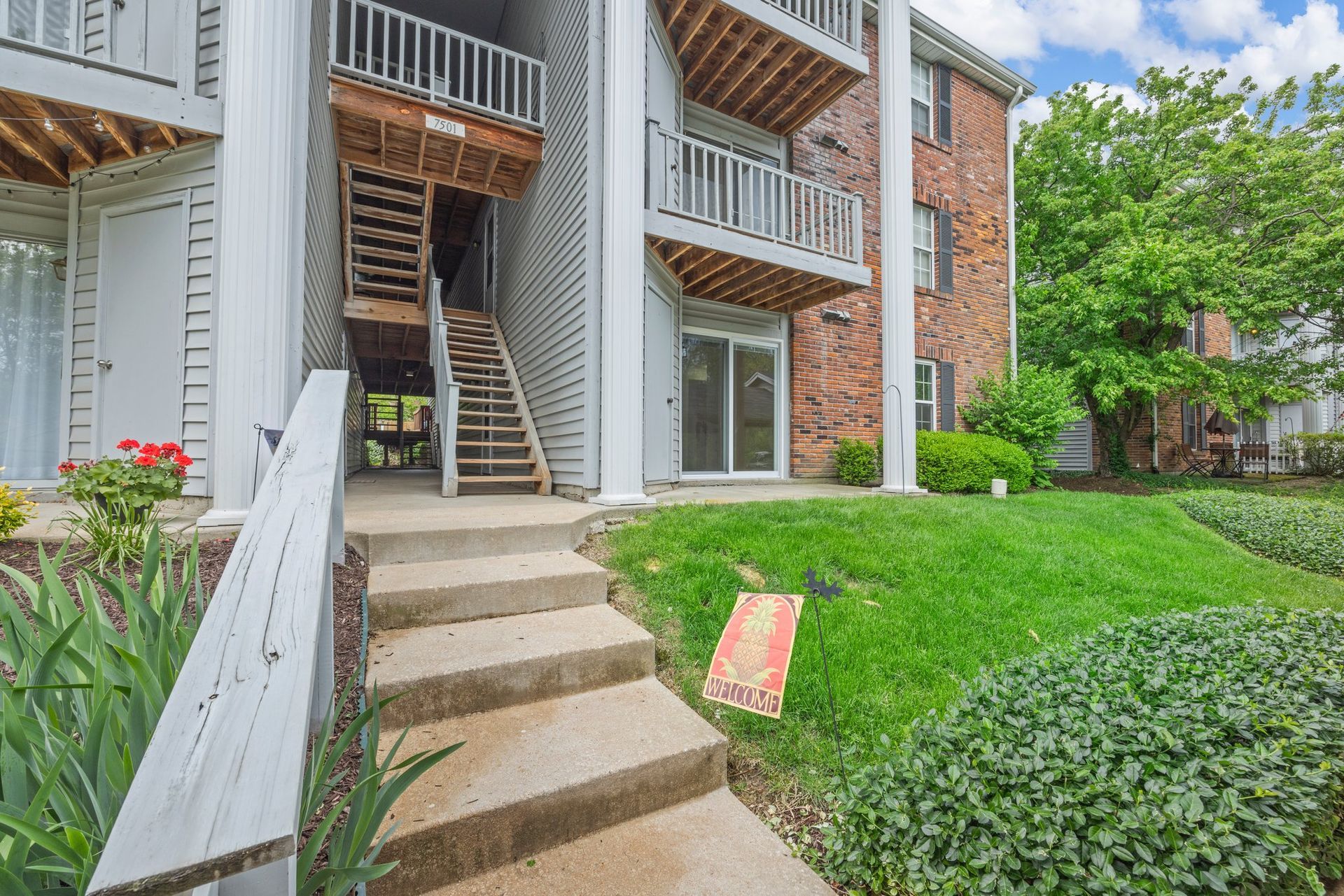 A brick apartment building with stairs leading up to the second floor.