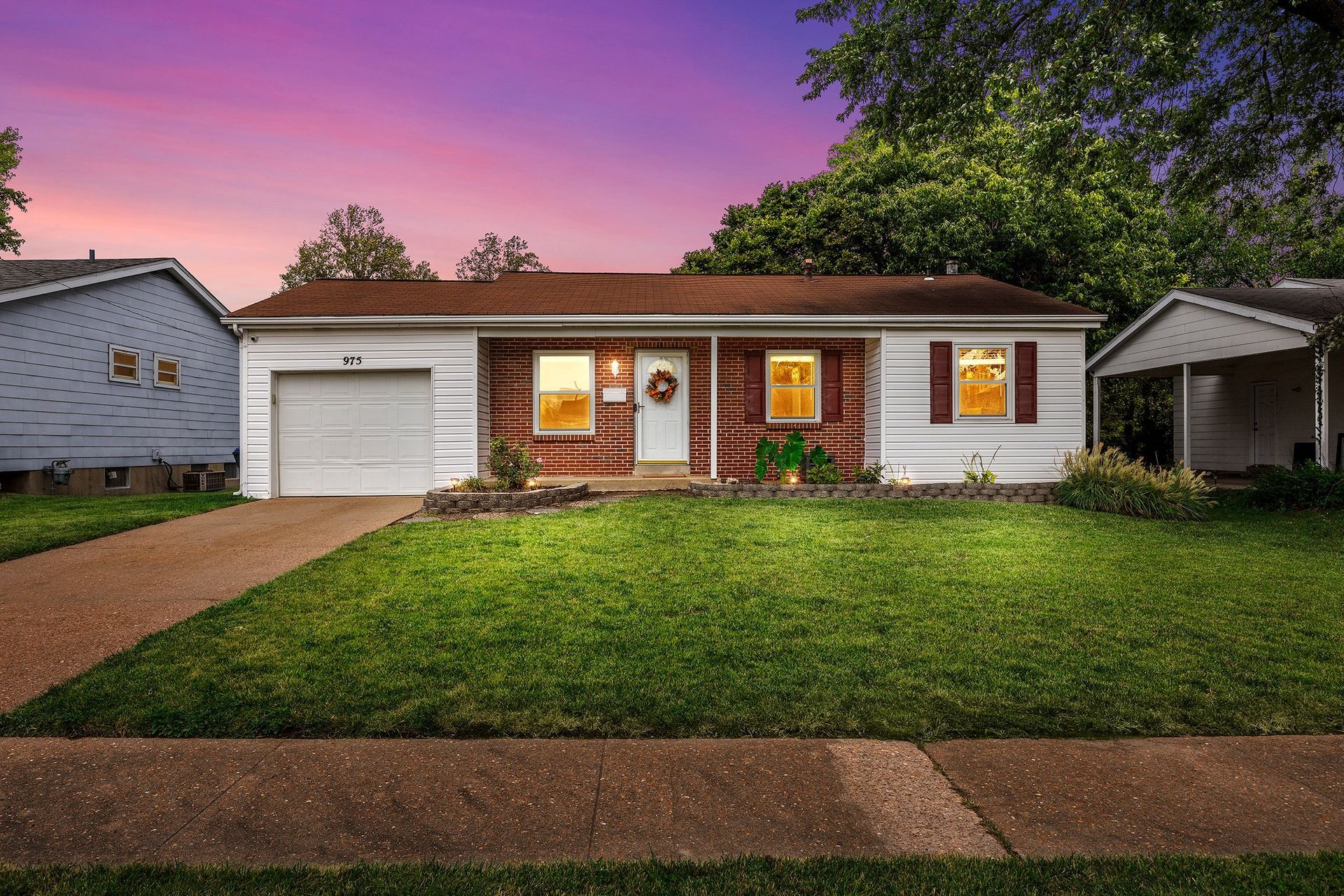 A house with a large lawn and a garage is for sale.