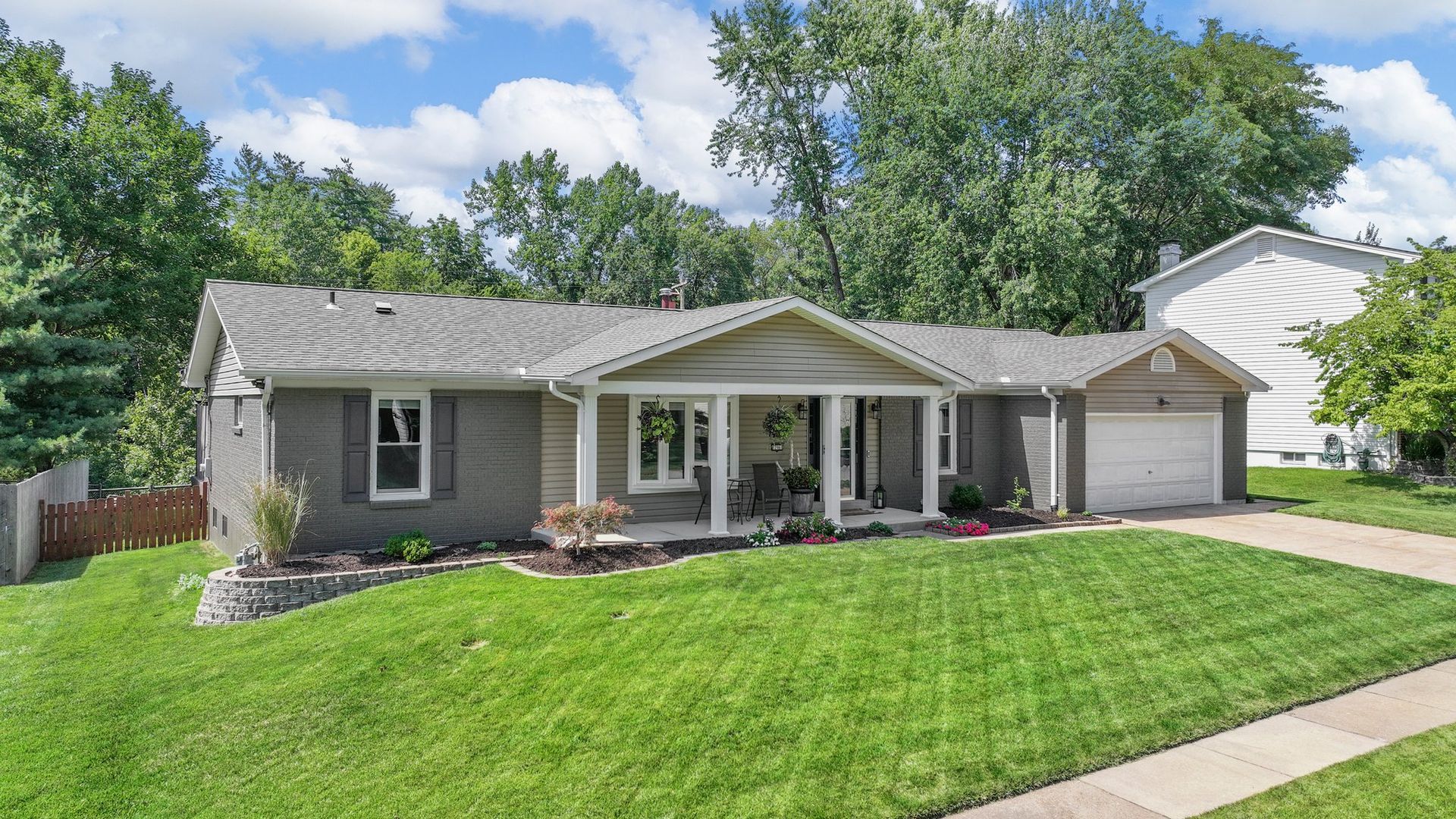 A house with a large lawn and a garage is for sale.