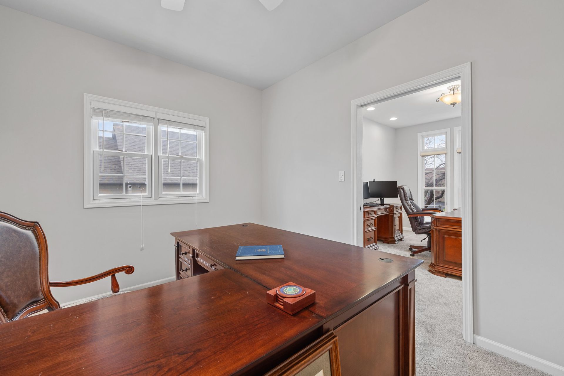 A home office with a large wooden desk and chair.