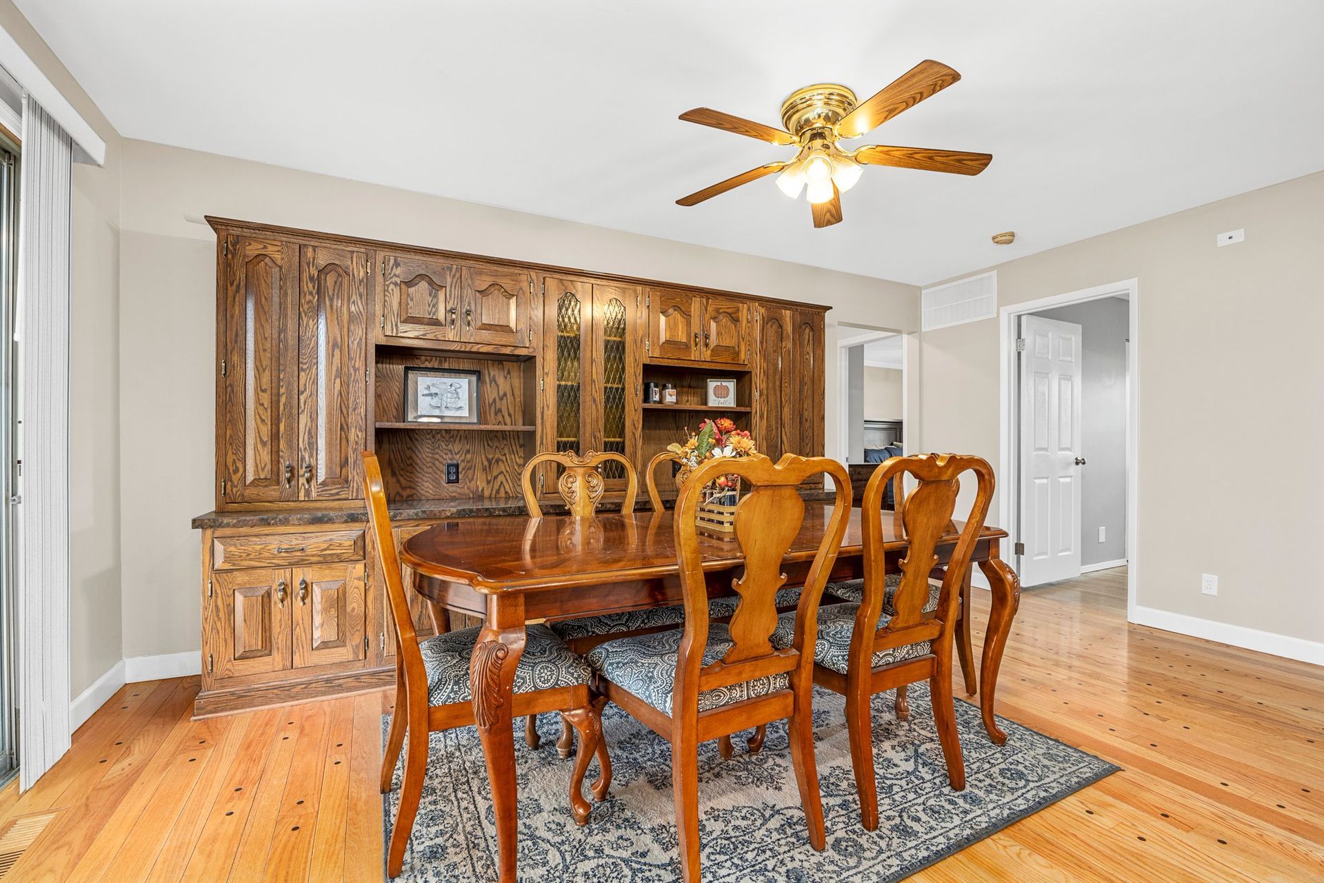 A dining room with a table and chairs and a ceiling fan