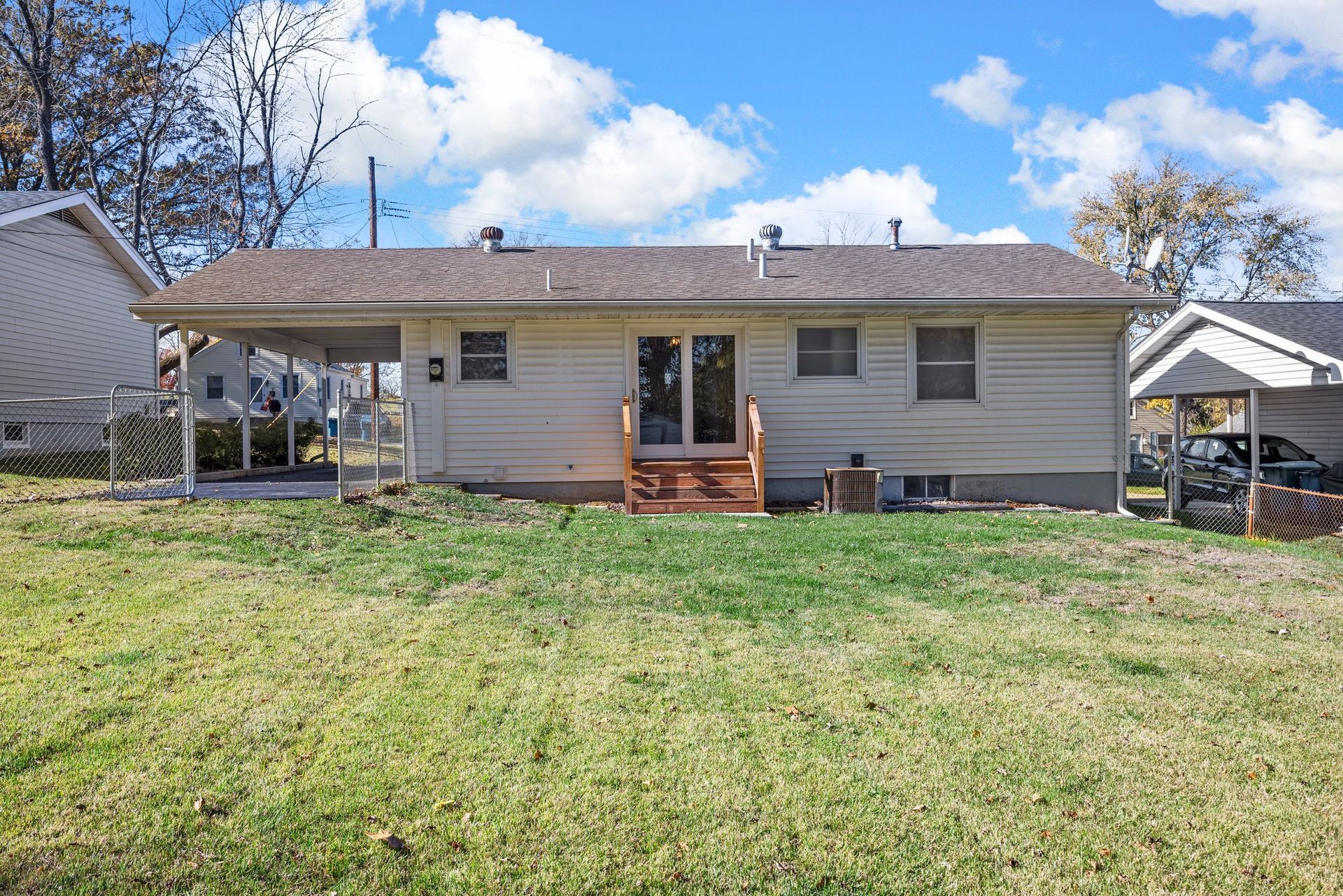 The back of a house with a large lawn in front of it.