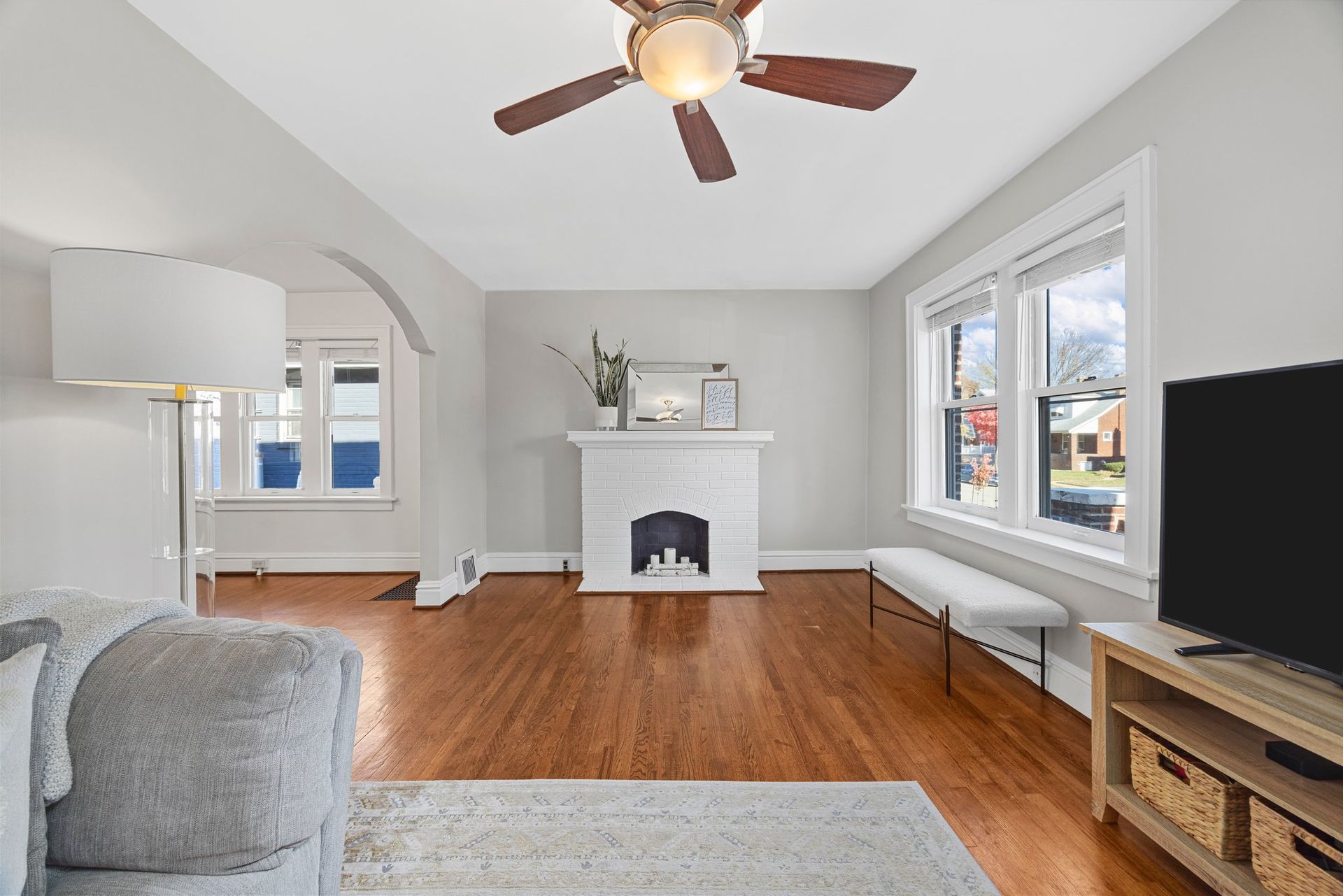 A living room with a fireplace and a ceiling fan