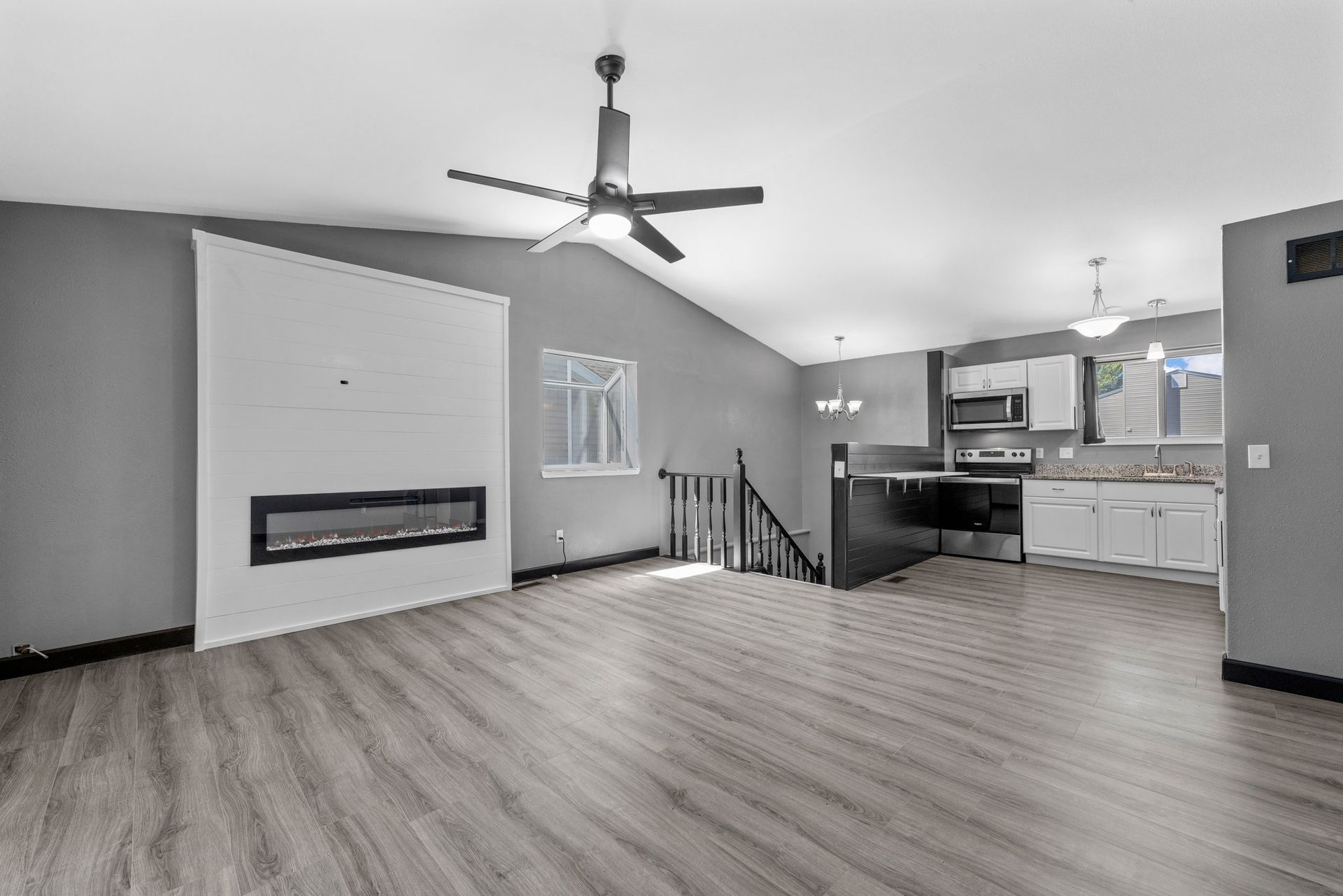There is a ceiling fan in the living room and a fireplace in the kitchen.