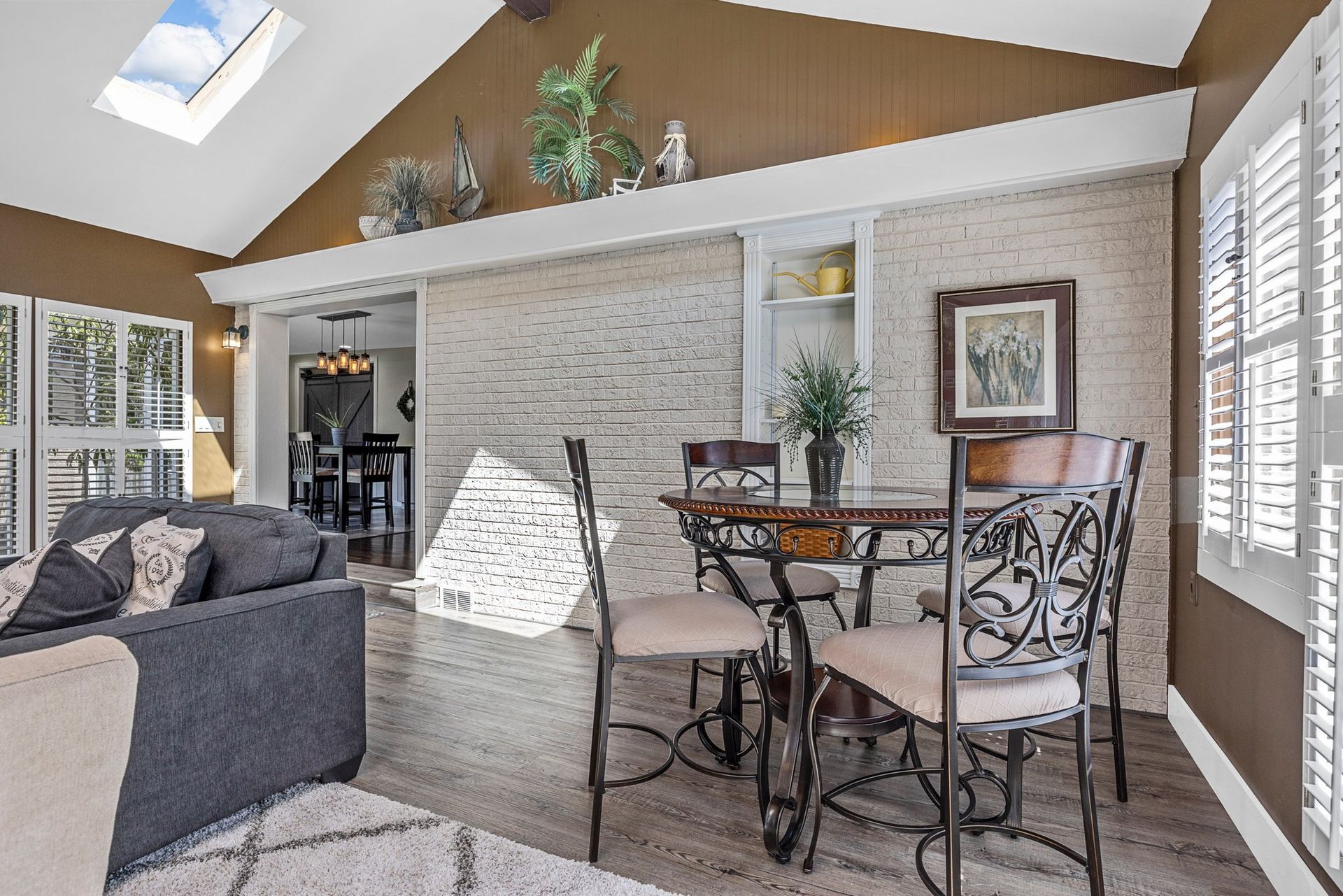A living room with a table and chairs and a skylight.