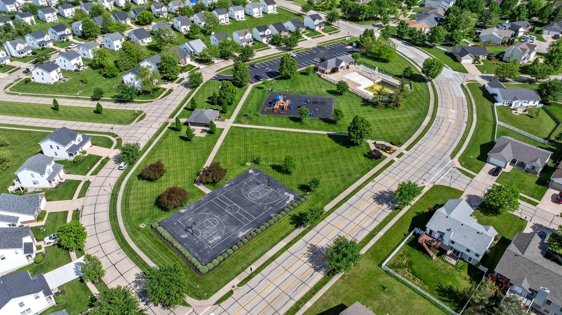 An aerial view of a residential area with lots of houses and a playground.