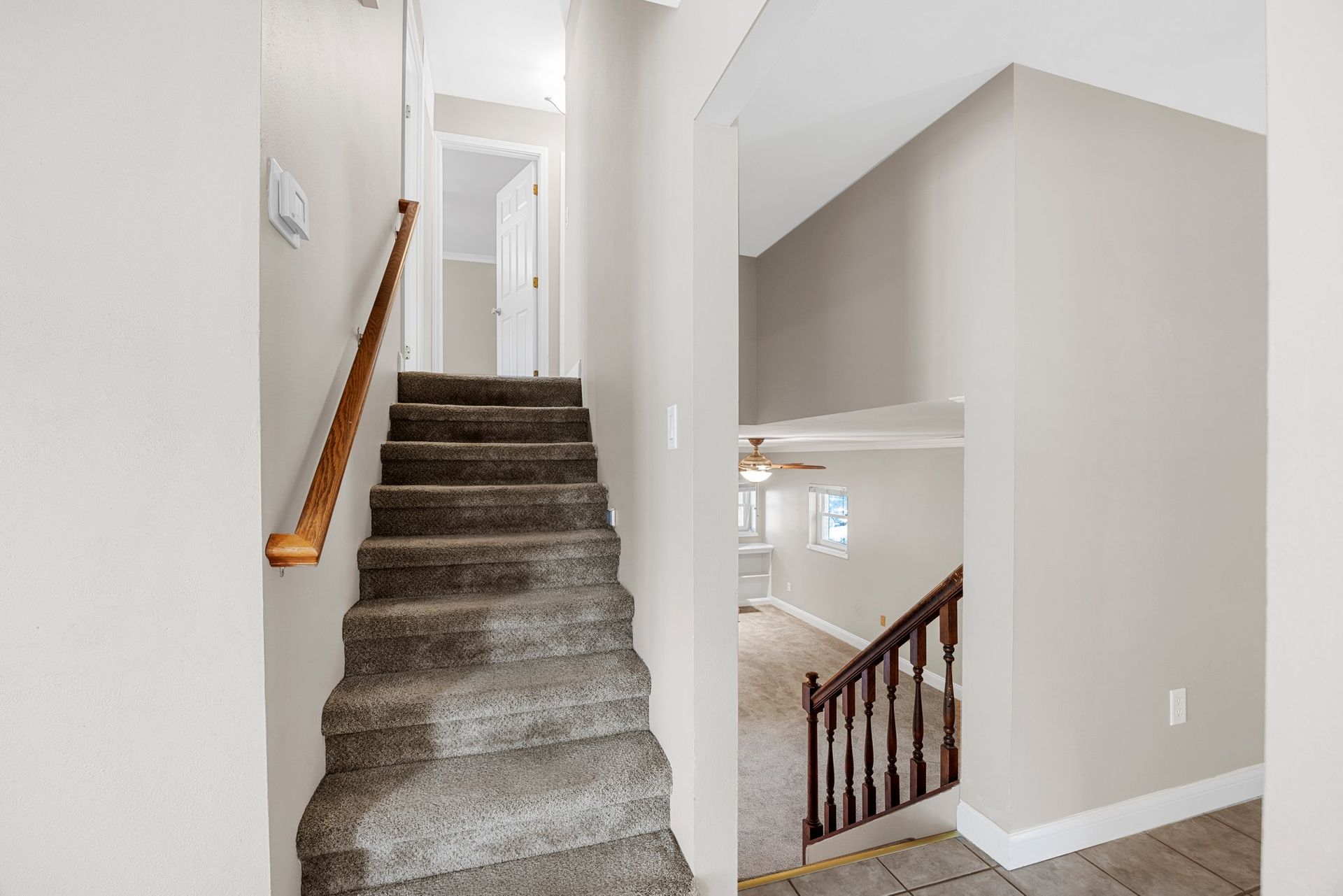 A hallway with stairs leading up to the second floor of a house.
