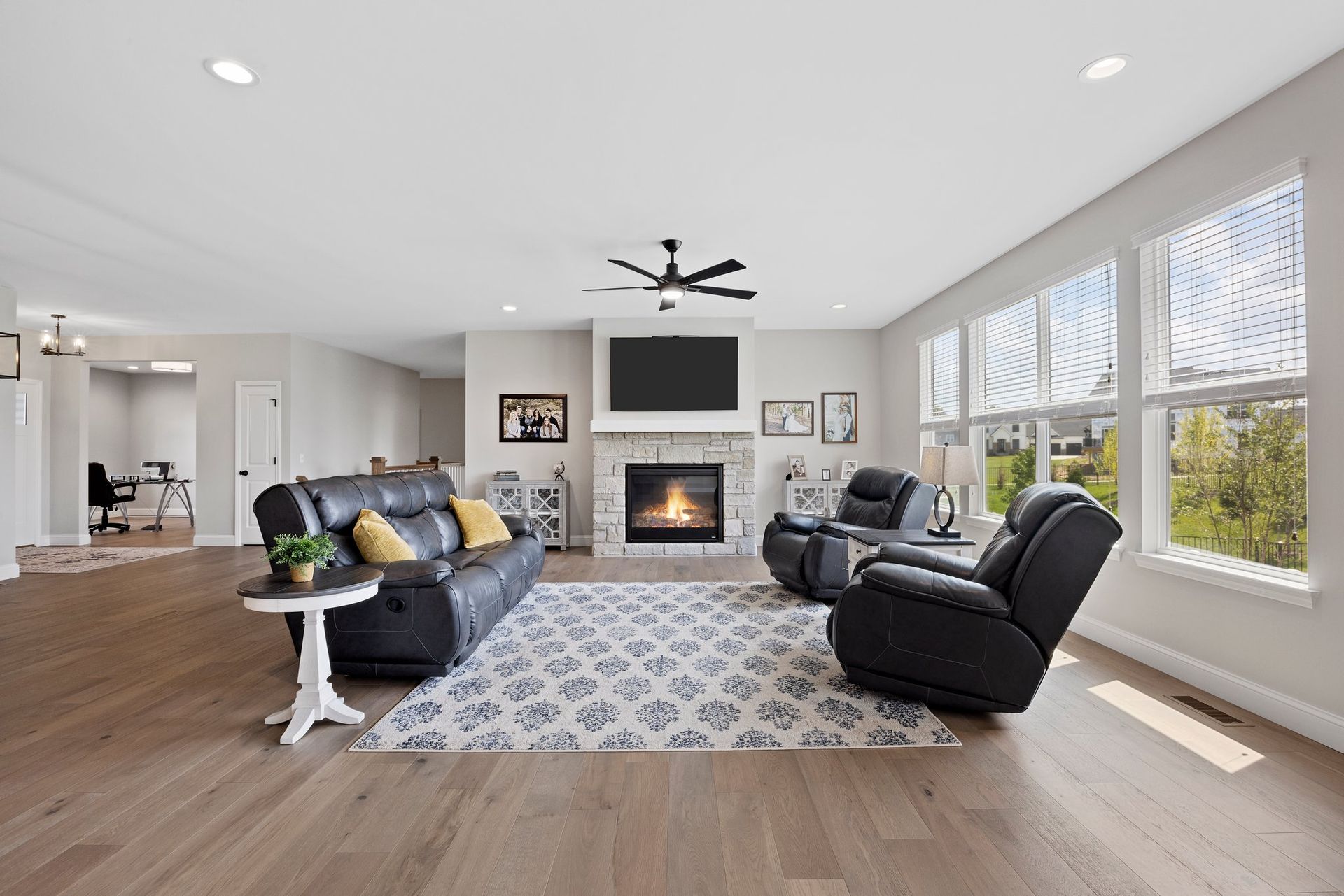 A living room with a couch , chairs , fireplace and television.