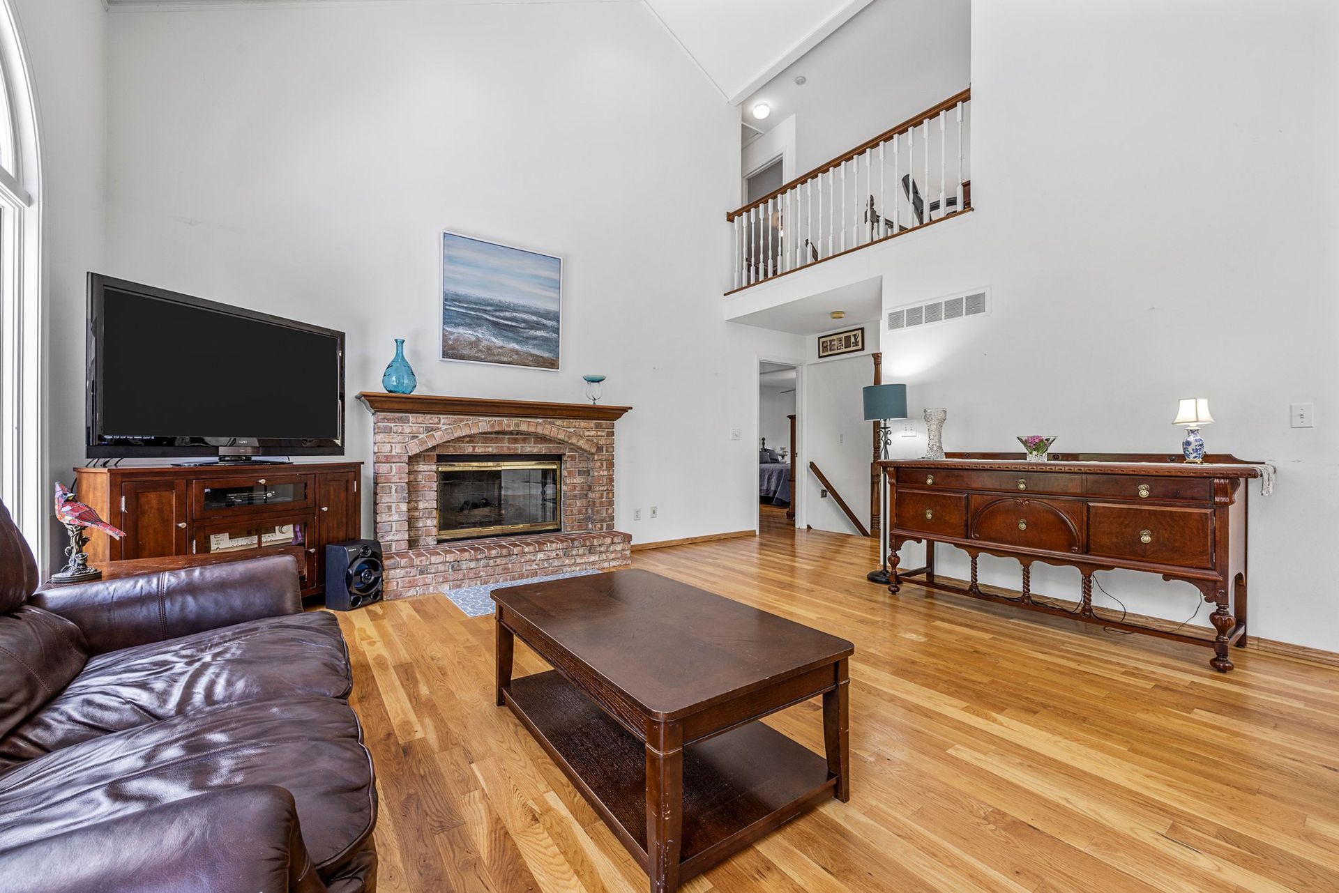 A living room with a couch , coffee table , fireplace and television.