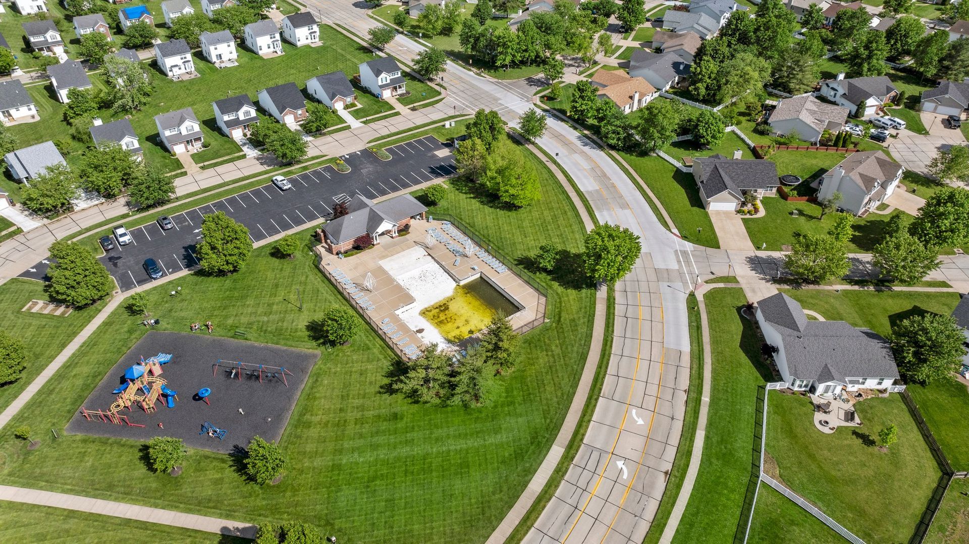 An aerial view of a residential area with a park and a playground.