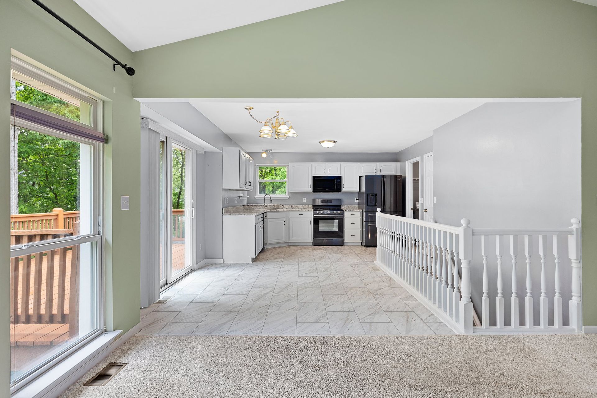 An empty house with a kitchen , living room , and stairs.