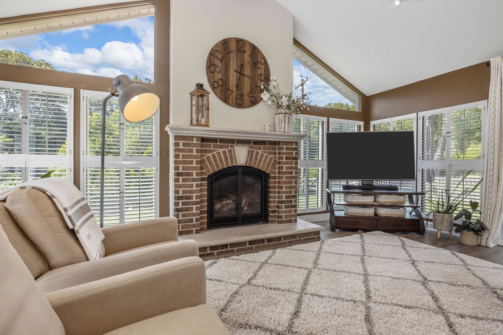 A living room with a fireplace and a flat screen tv.