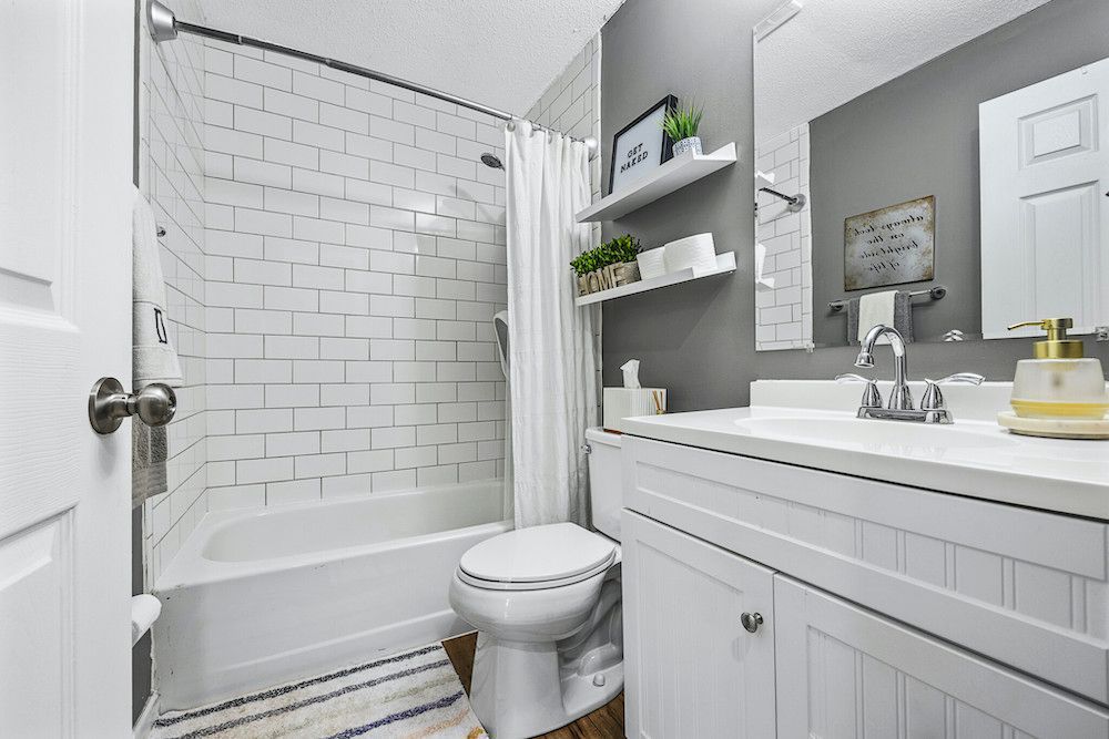 A bathroom with a toilet , sink , and bathtub.