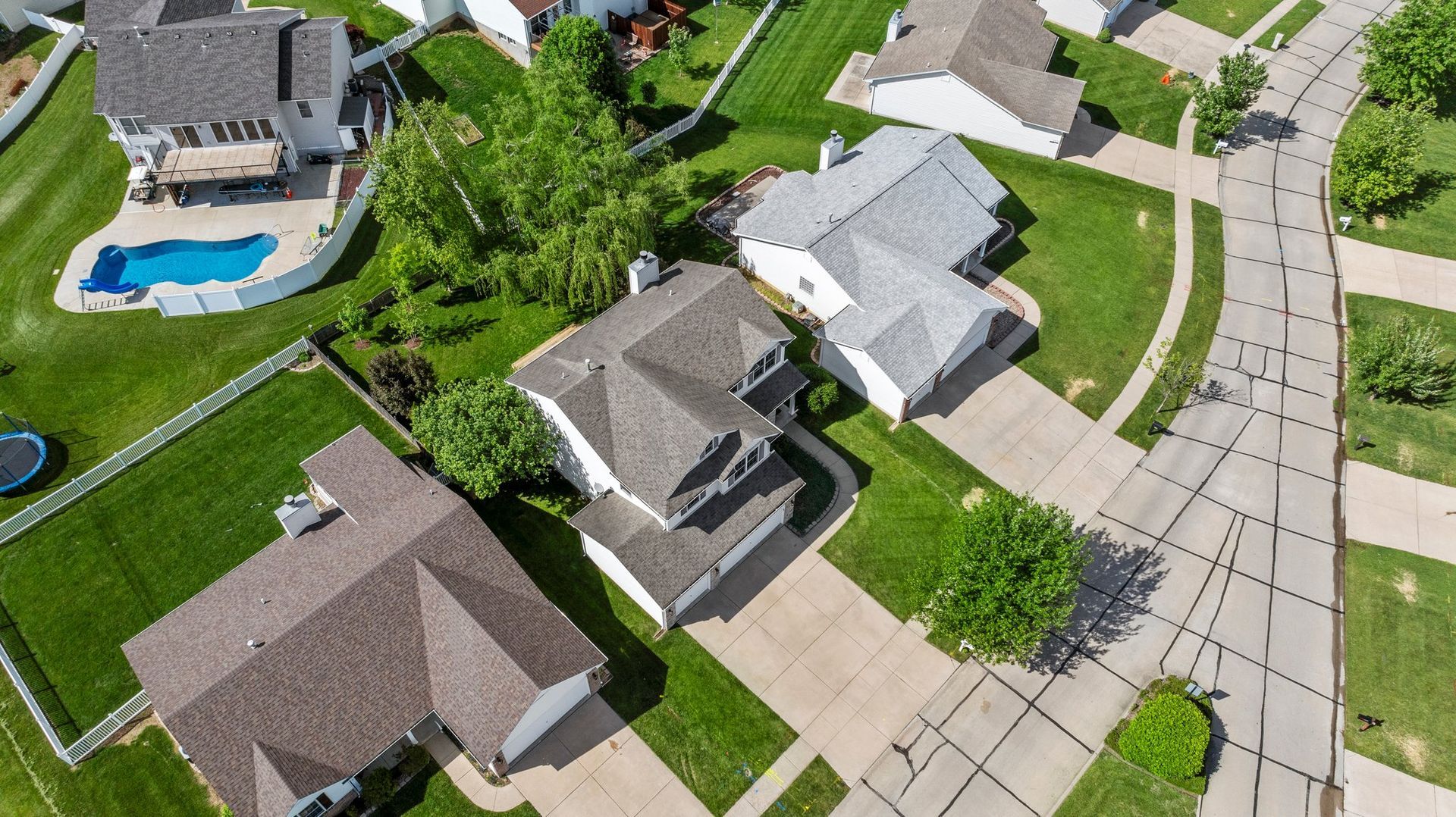 An aerial view of a residential neighborhood with houses and a pool.