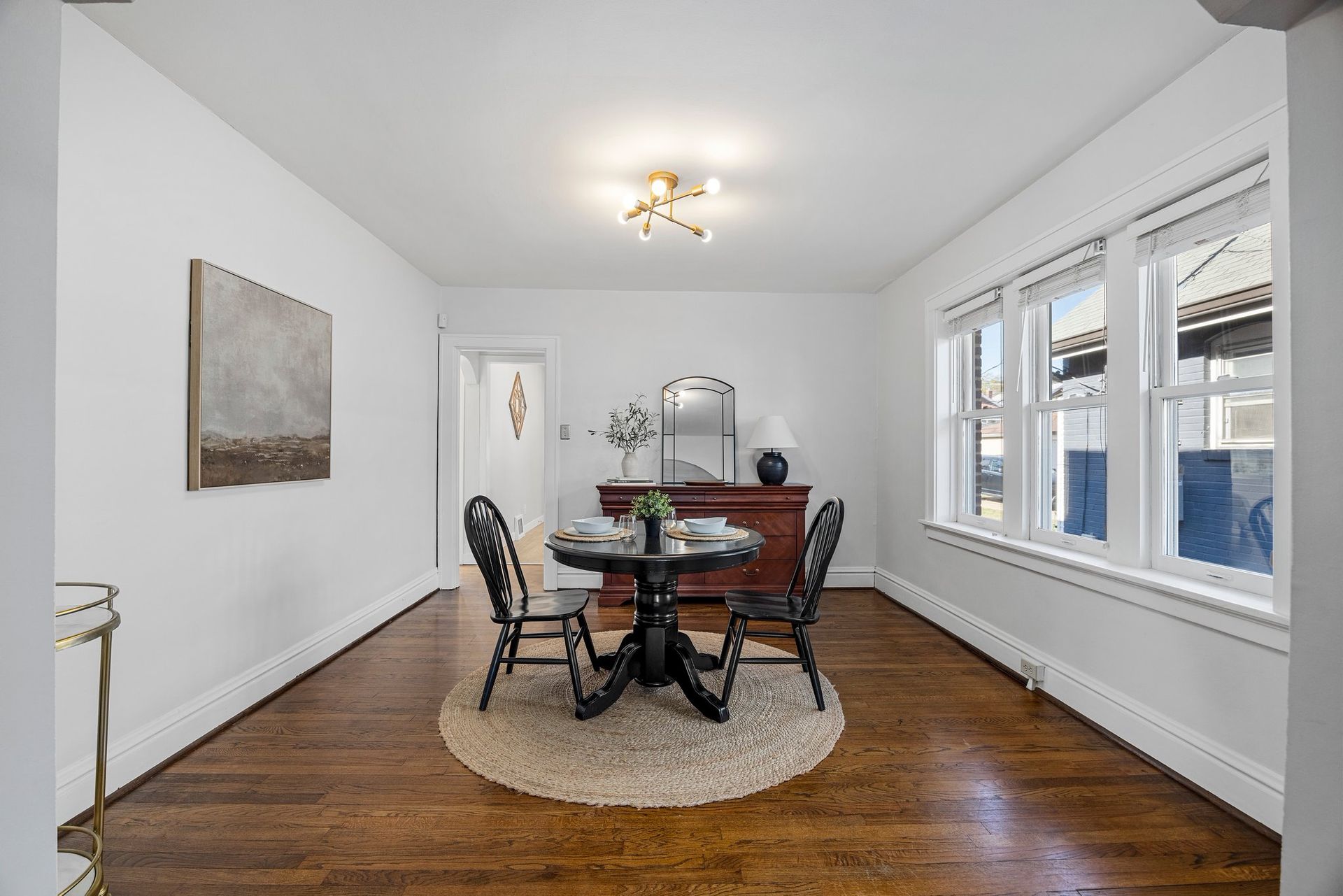 A dining room with a table and chairs and a rug.
