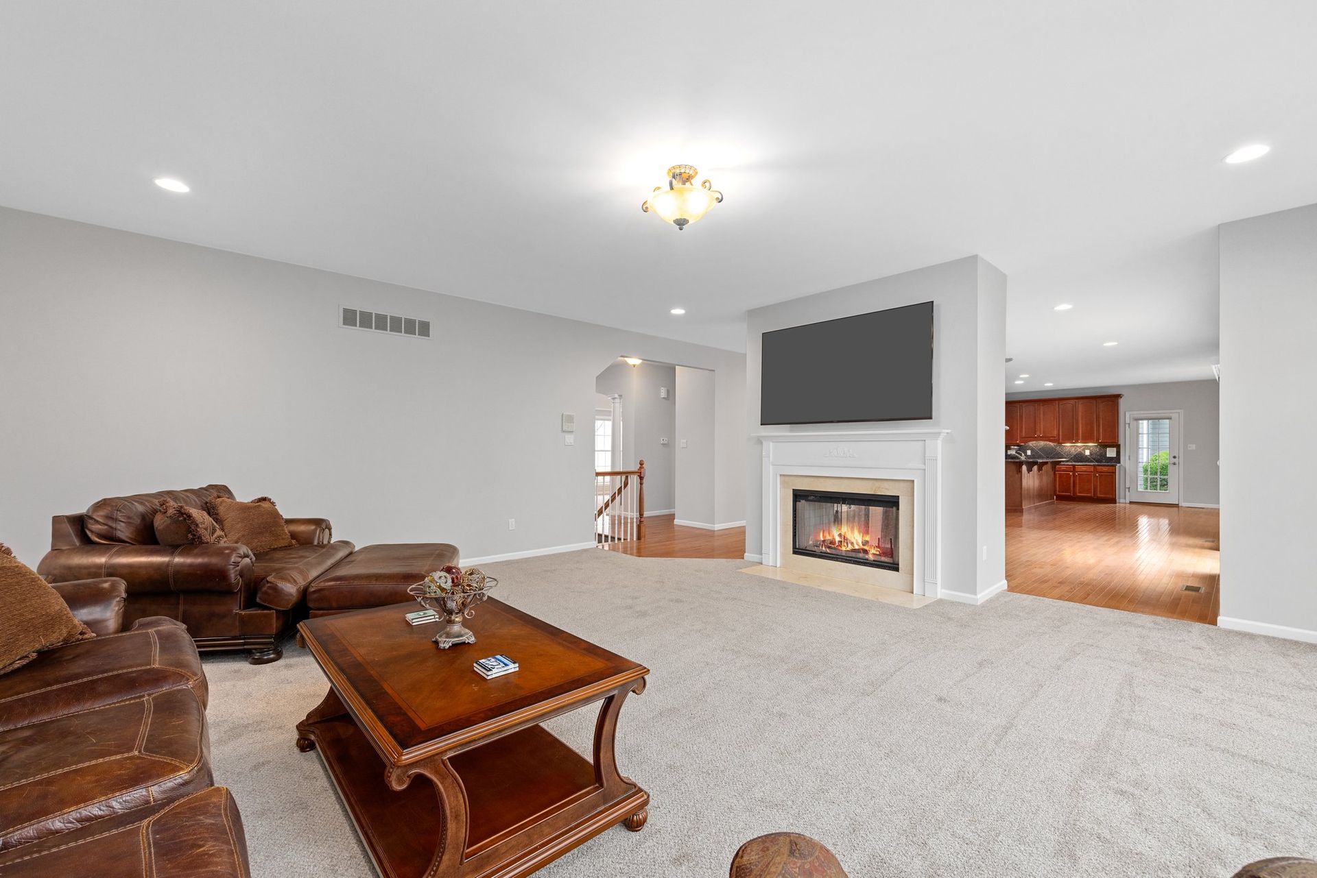 A living room with a fireplace , couch , coffee table and television.