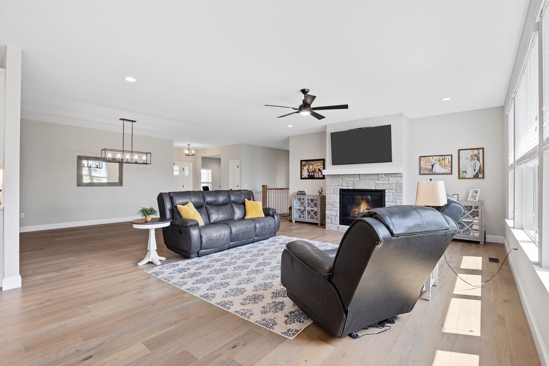 A living room with a couch , chair , fireplace and television.