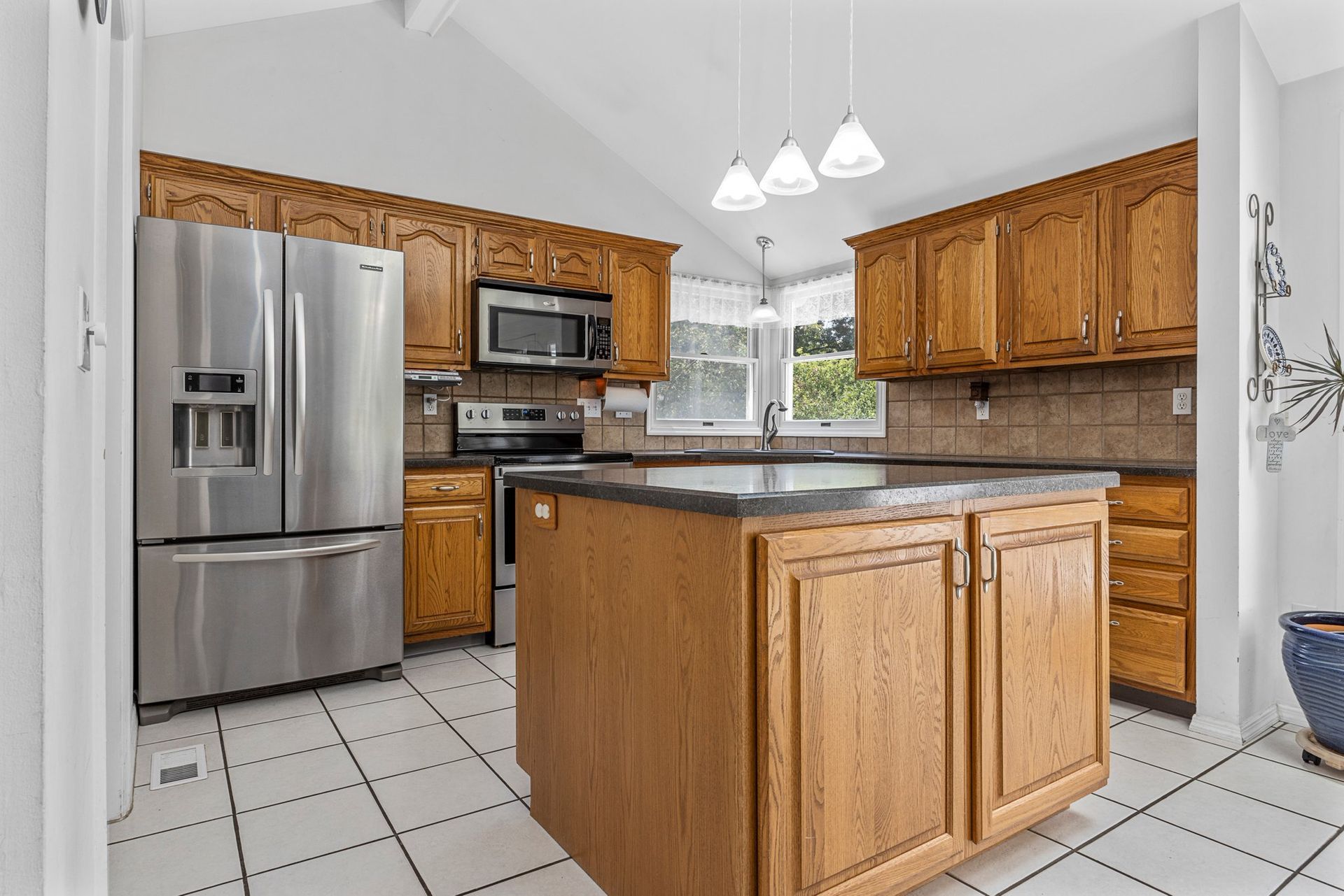 A kitchen with stainless steel appliances and wooden cabinets.