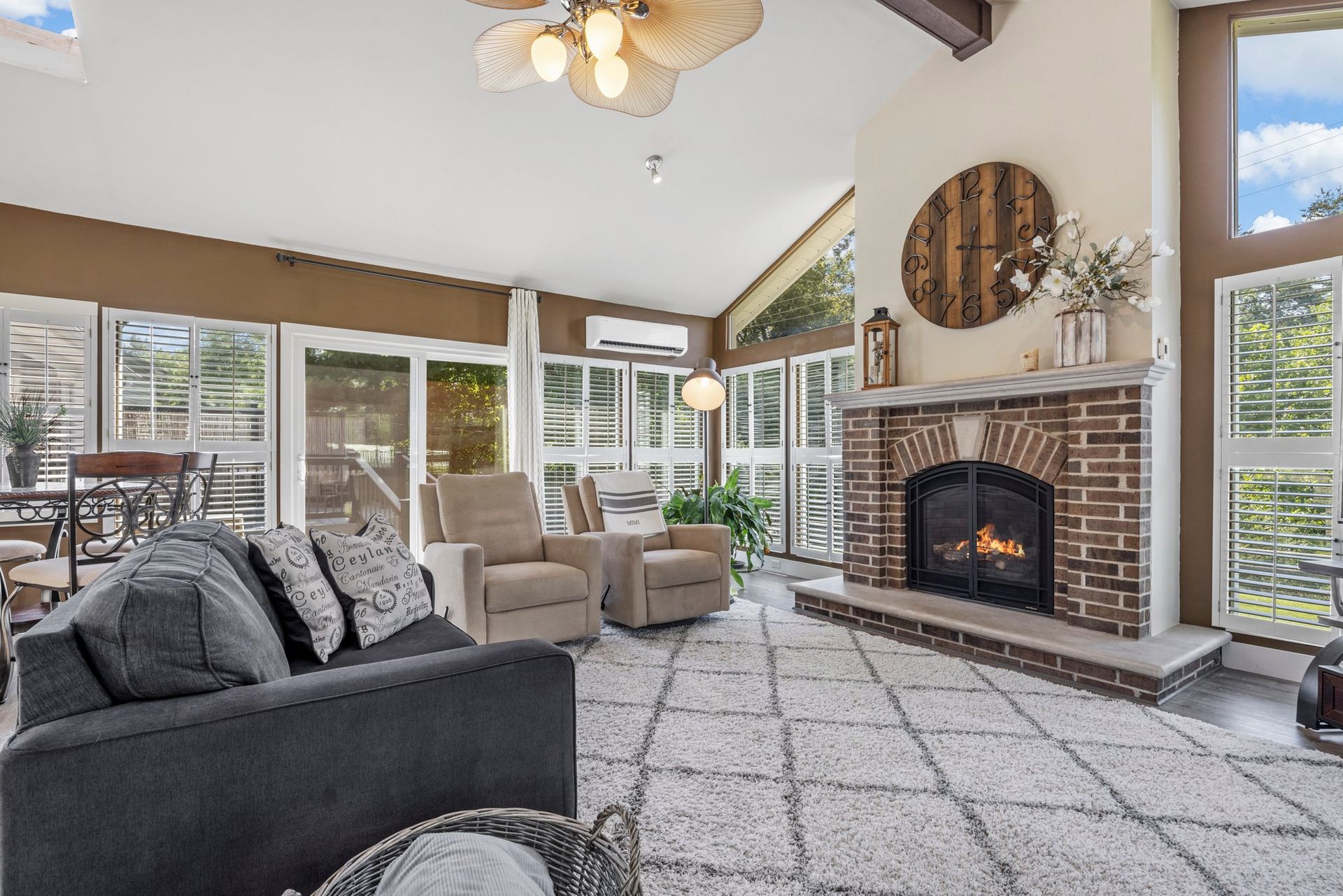 A living room with a couch , chairs , and a fireplace.