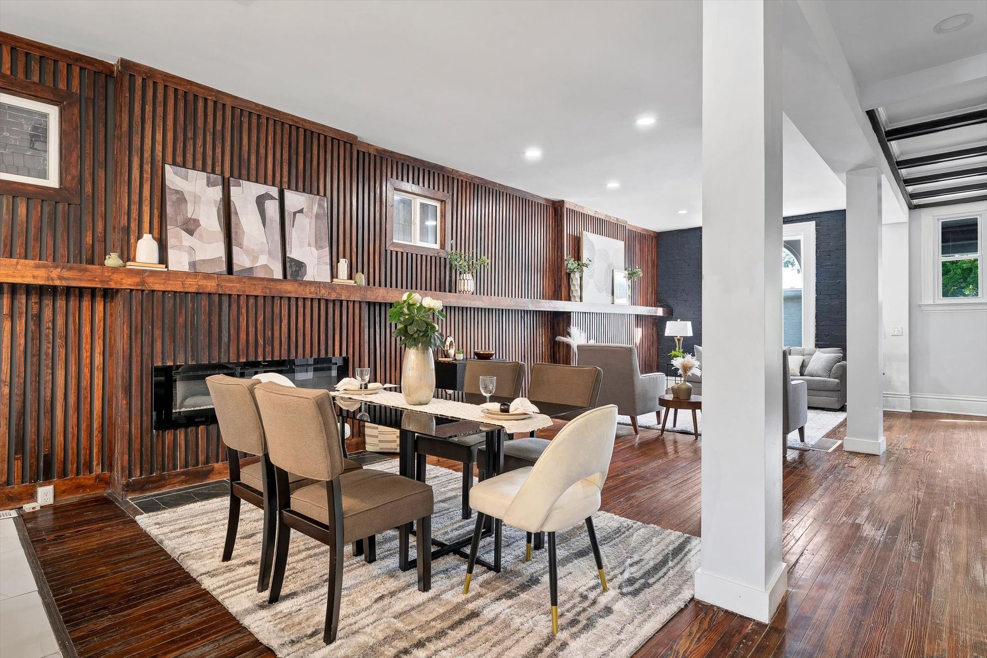 Dining room with wood paneling, table set for dinner, and open to living room.