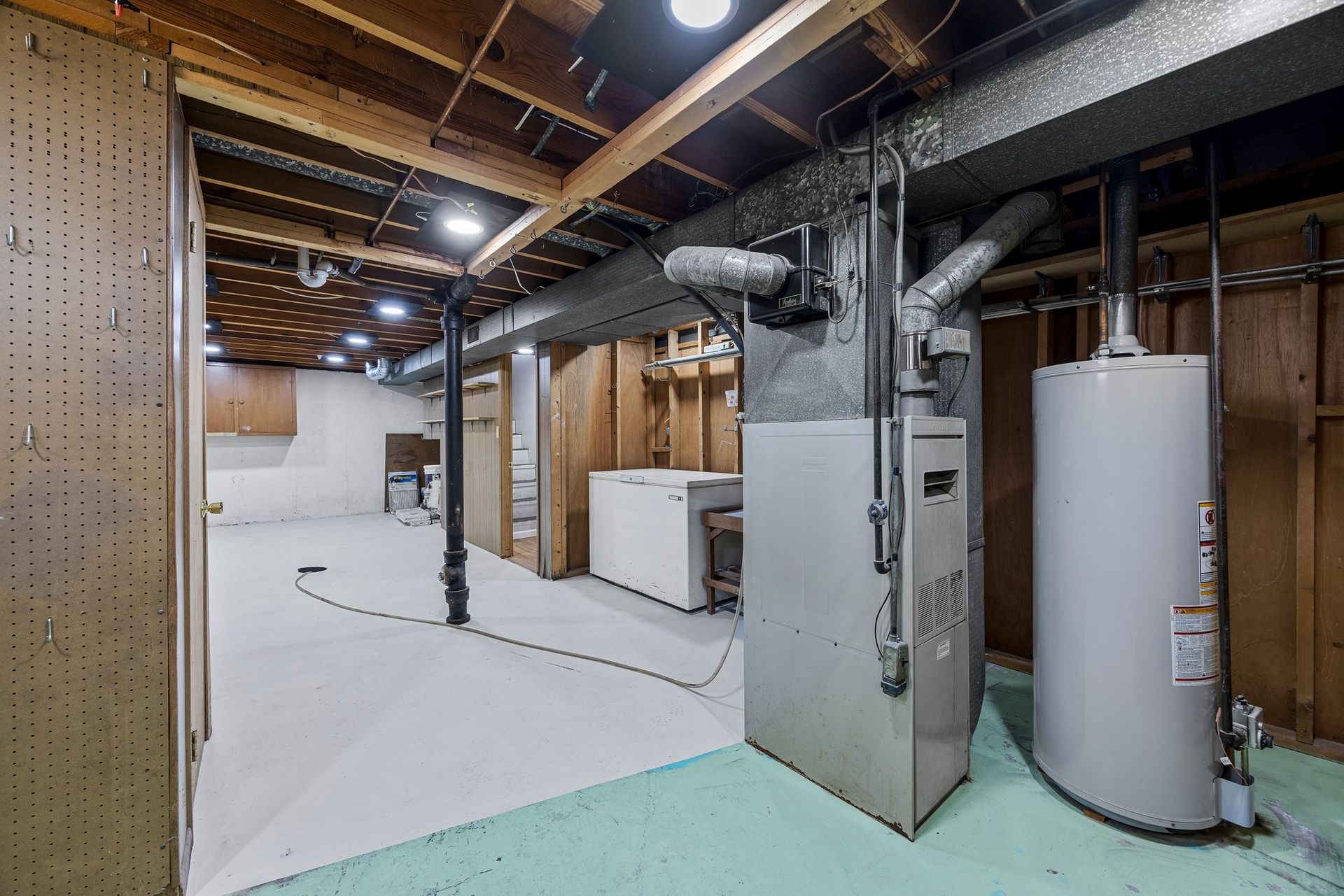A basement with a water heater and a furnace.