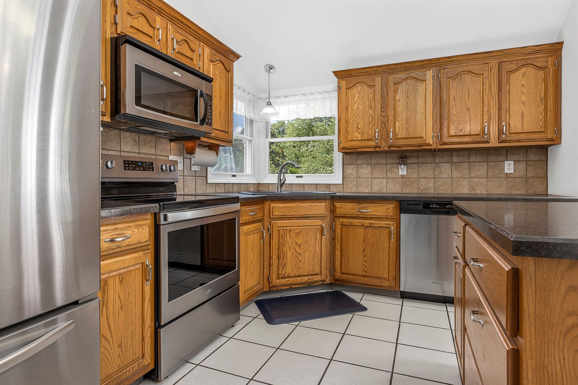 A kitchen with stainless steel appliances and wooden cabinets.