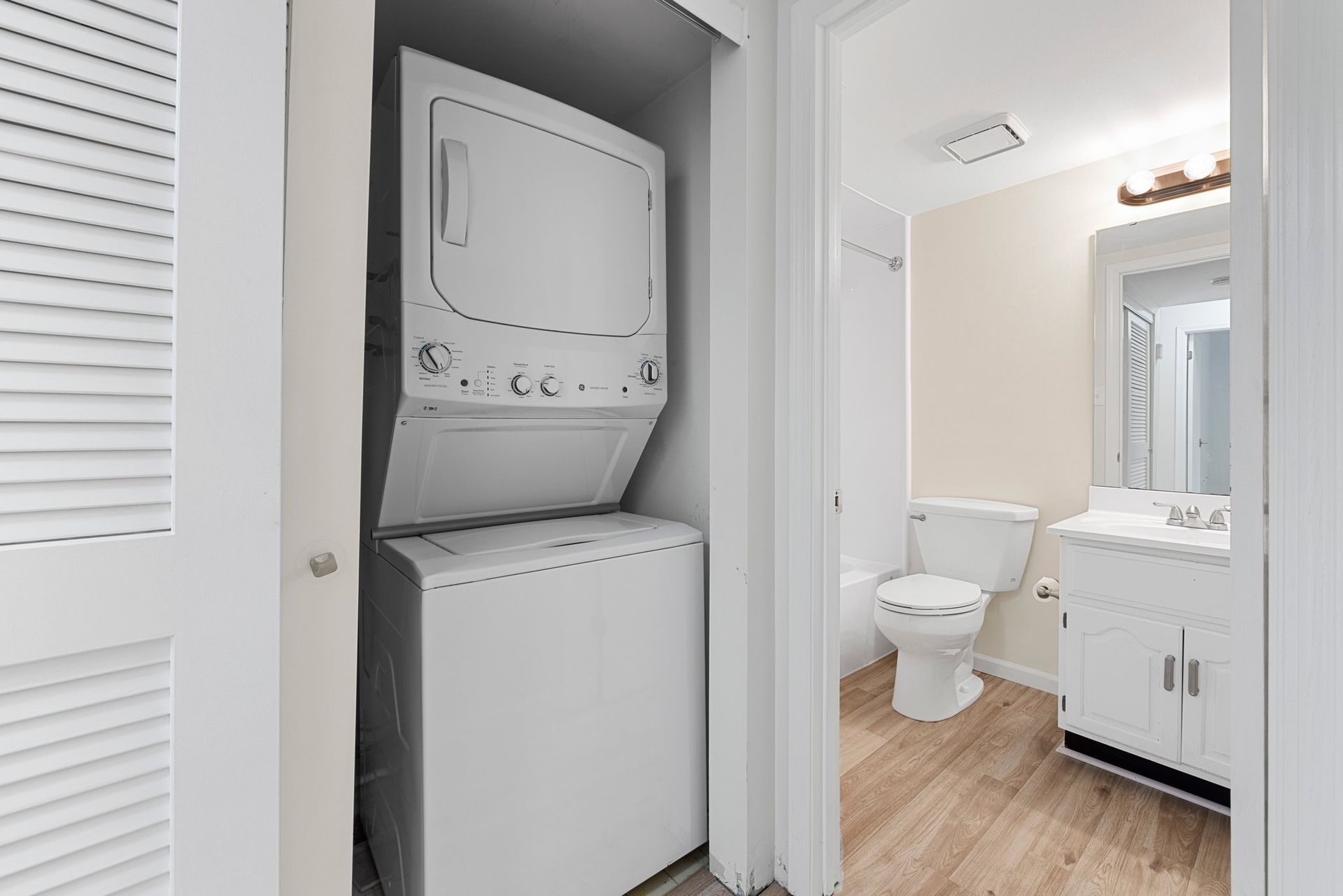 A washer and dryer are stacked on top of each other in a bathroom.
