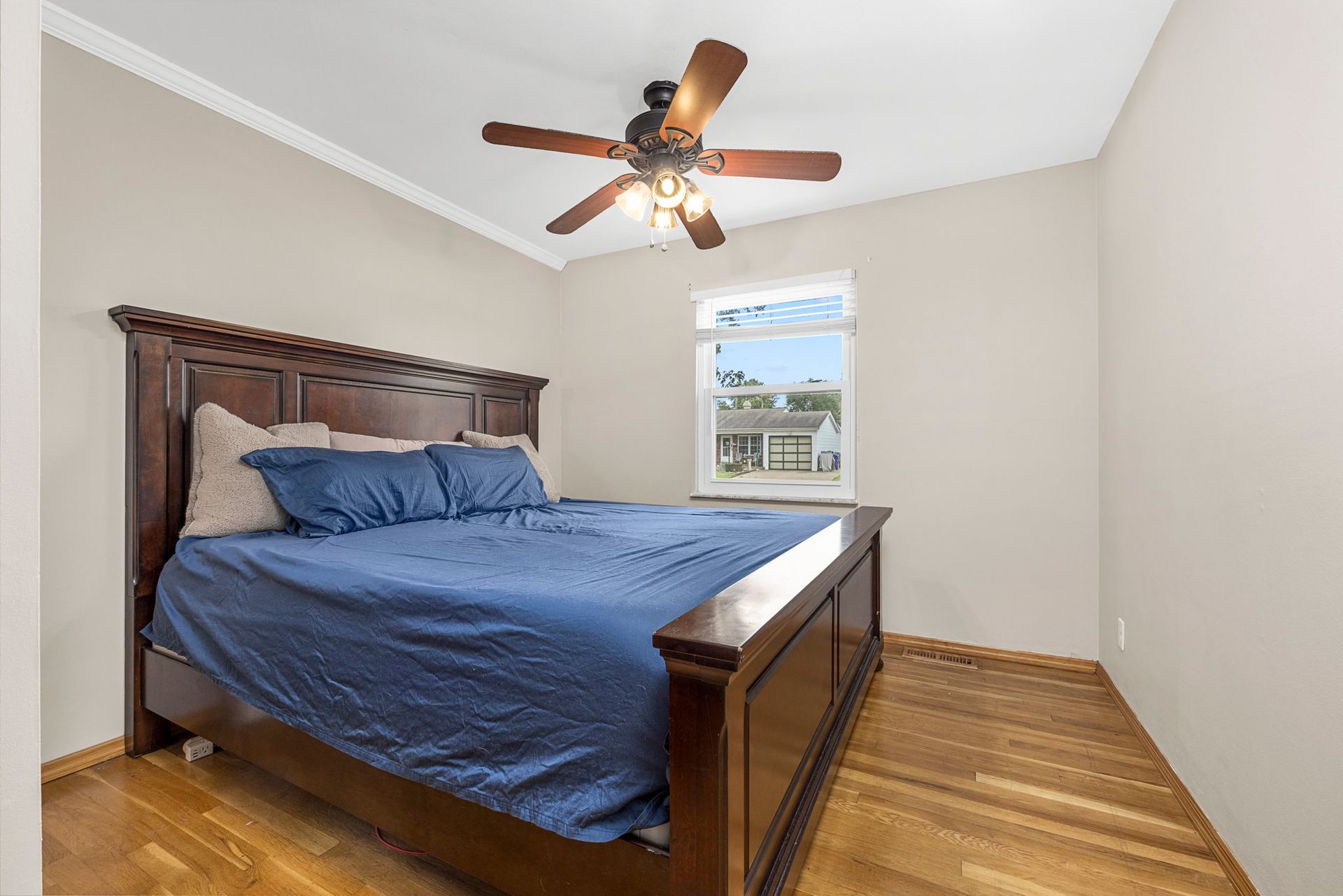 A bedroom with a bed , ceiling fan and window.