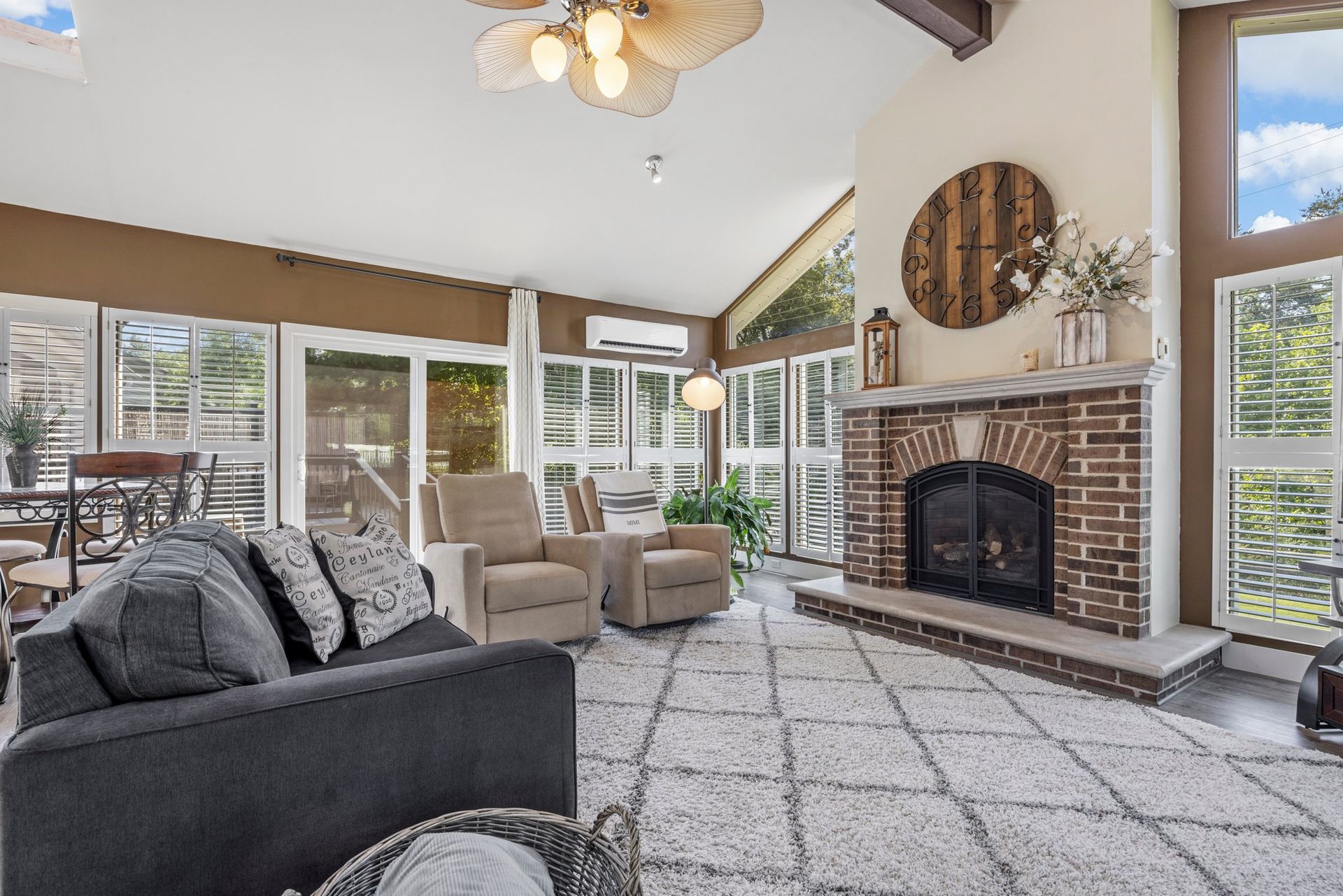 A living room with a couch , chairs , and a fireplace.