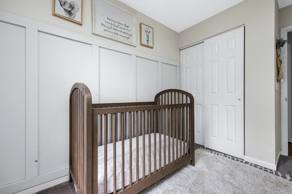 A baby crib is sitting in a nursery next to a closet.