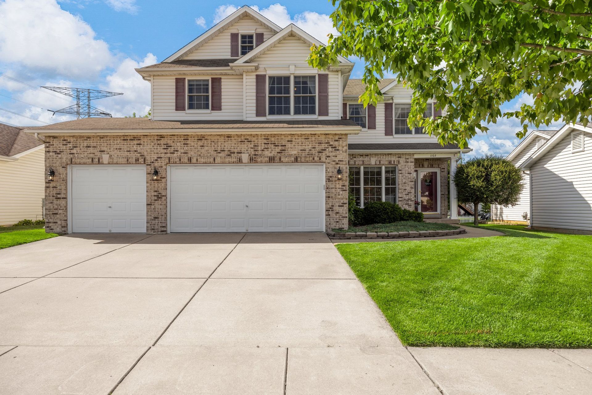 A large house with two garage doors and a concrete driveway