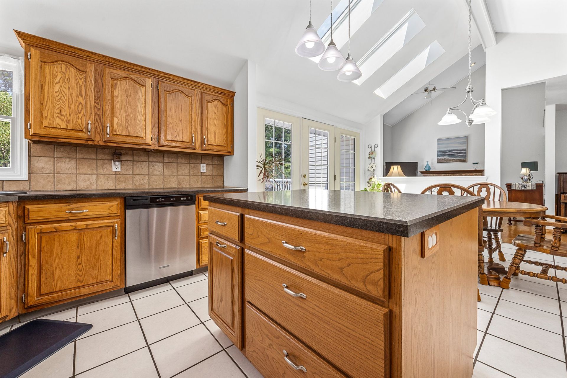 A kitchen with wooden cabinets , stainless steel appliances , and a large island.