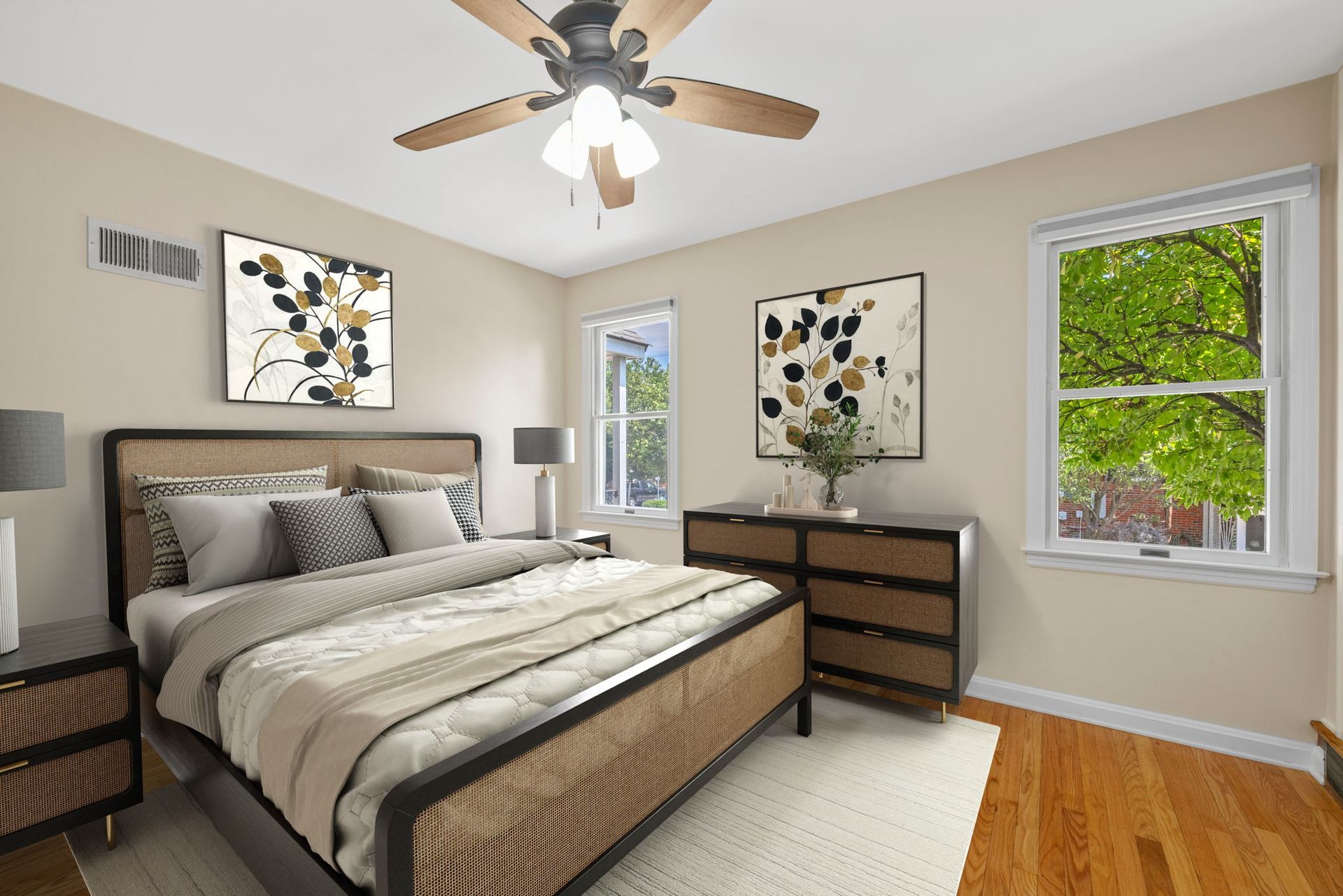 A bedroom with a bed , dresser , nightstand and ceiling fan.