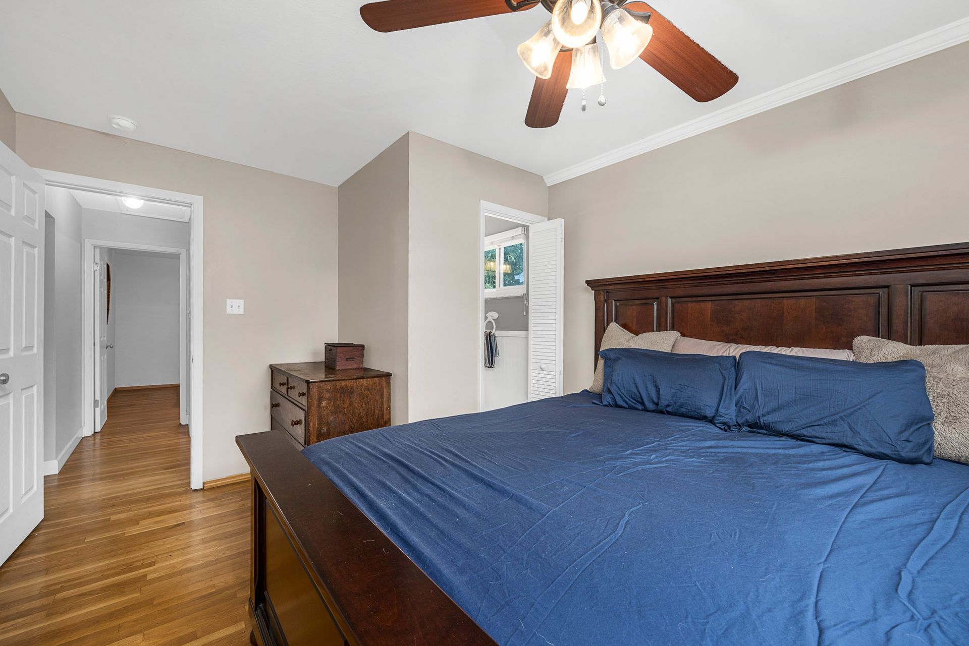 A bedroom with a king size bed and a ceiling fan.