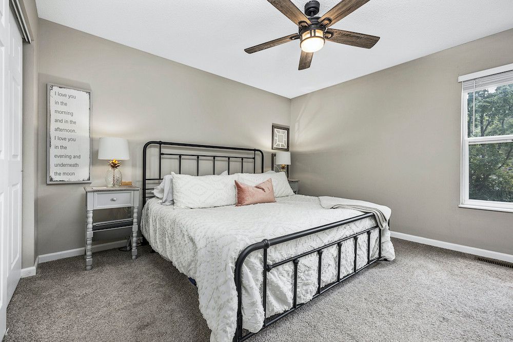 A bedroom with a large bed and a ceiling fan.